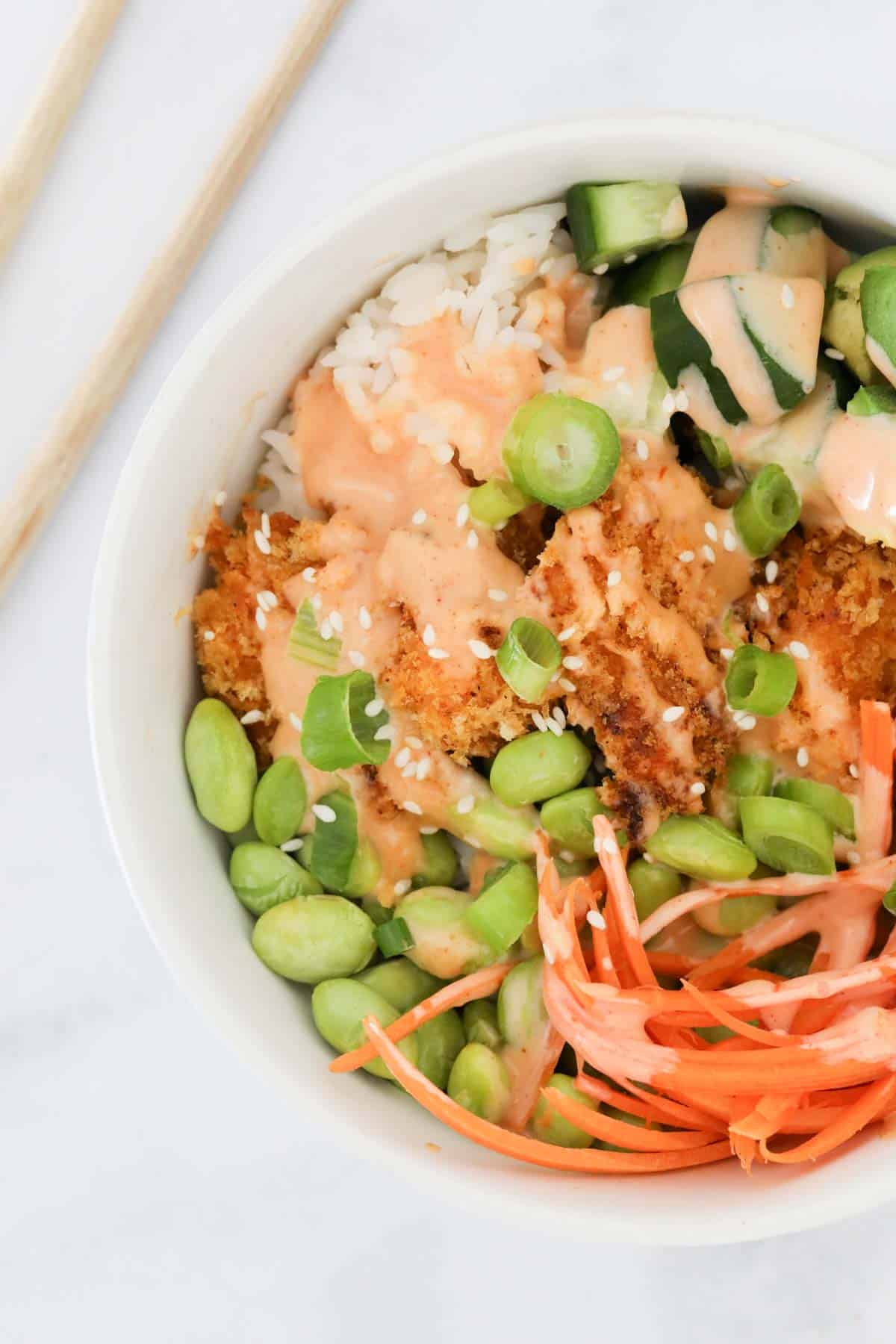 A bowl of the bang bang chicken served with a selection of vegetables and rice.