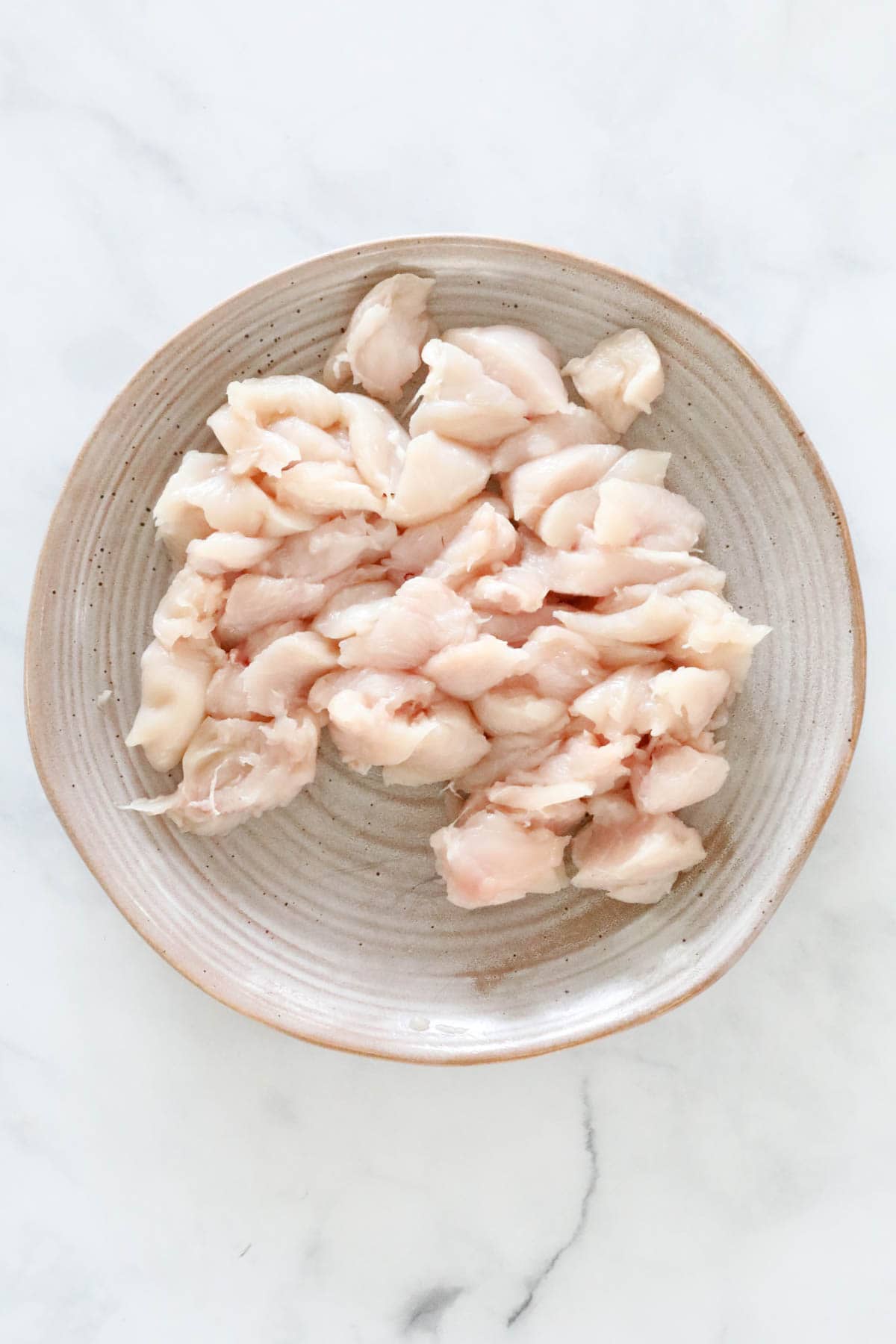 Chicken breast chopped into bite size pieces and placed in a bowl.