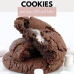 Three chocolate cookies with one showing marshmallow inside it.