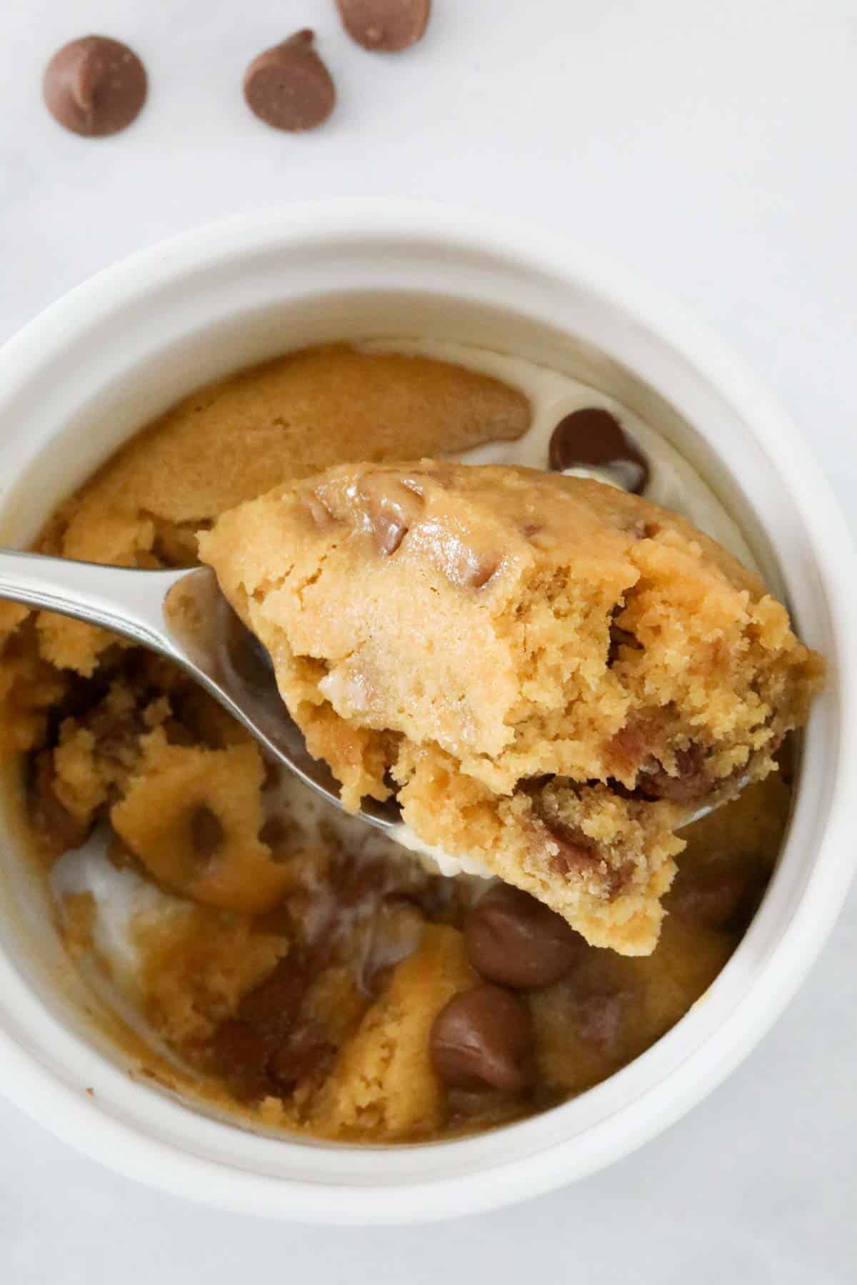 A spoonful of chocolate chip mug cake, held up above the mug.