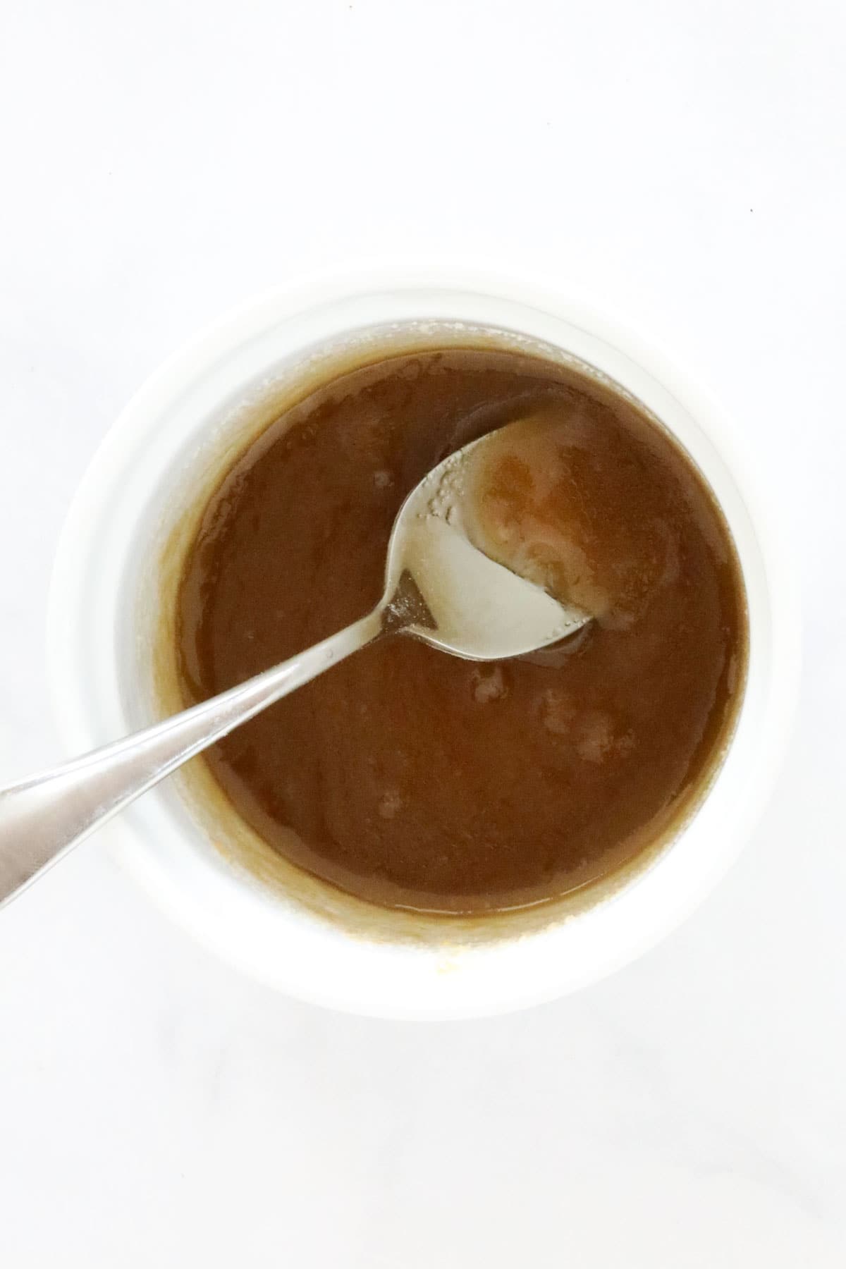 Sugar dissolved in melted butter in a mug.