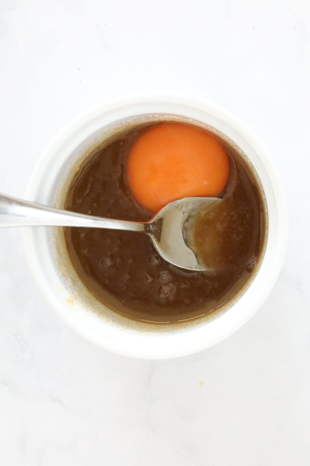 An egg yolk added to the sugar and butter mixture.