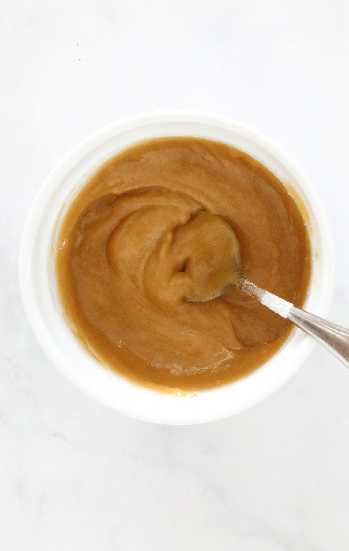 Flour stirred into the mixture in a mug.