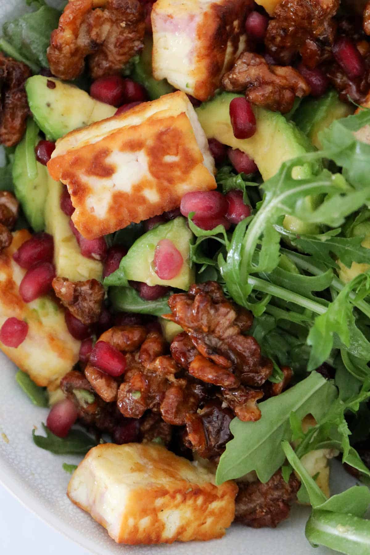 Honey walnuts and pomegranate seeds sprinkled over the salad.