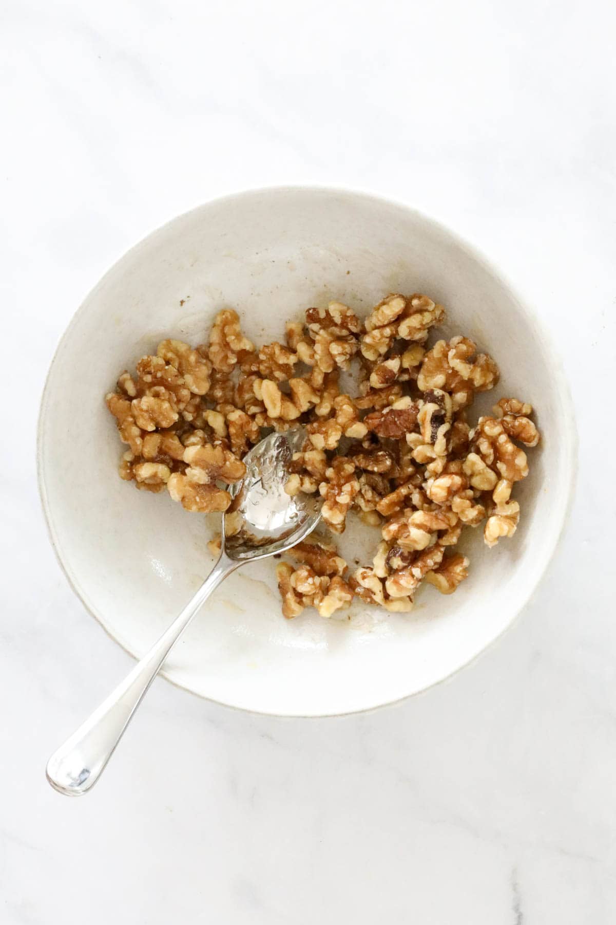 Walnut and honey mixed together in a bowl.