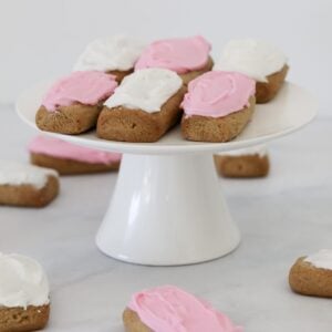 Pink and white icing on top of honey log biscuits.