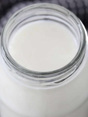 A glass jar filled with creamy buttermilk.