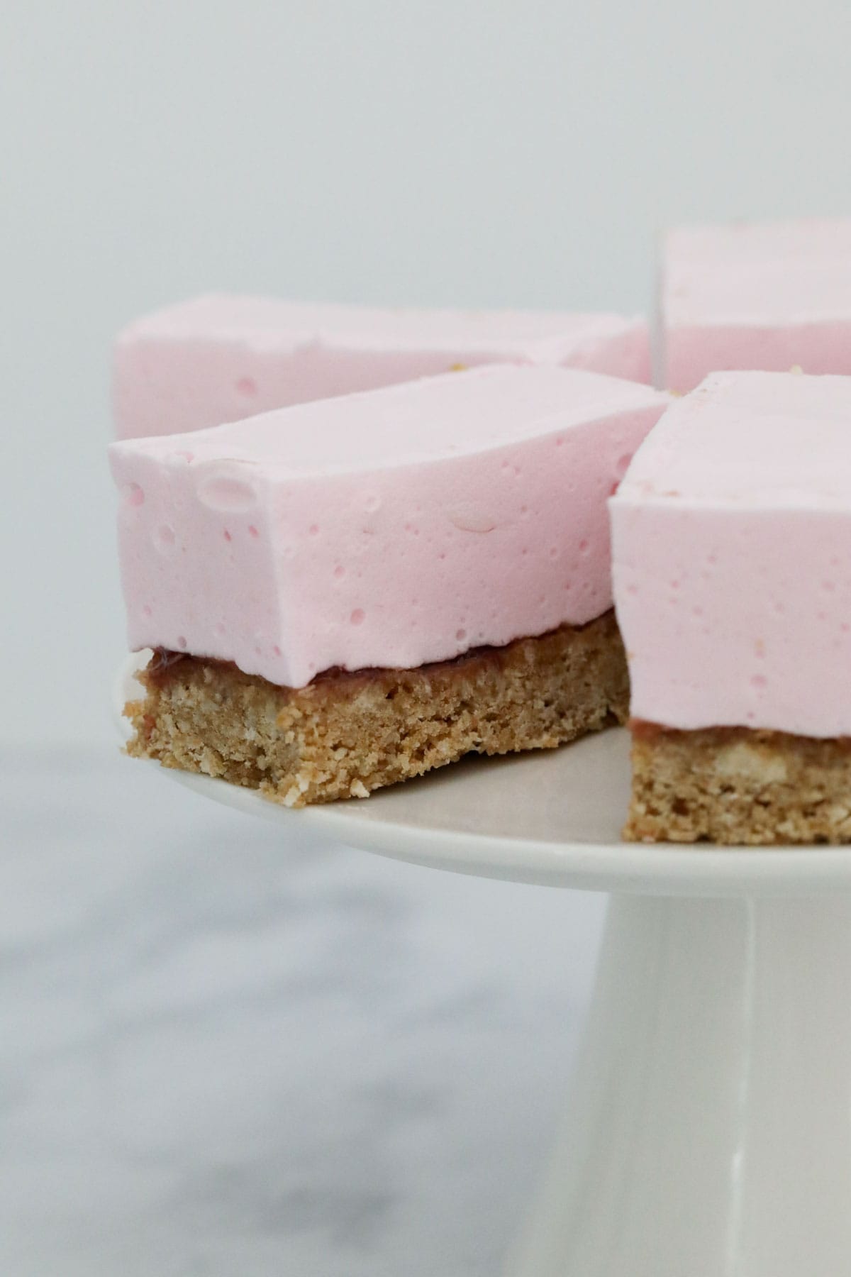 Marshmallow Weet-bix slice on a white cake stand.