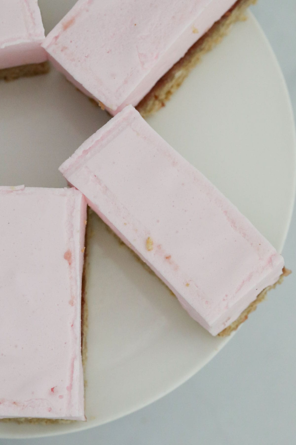 Top view of pink marshmallow slice on a white plate.