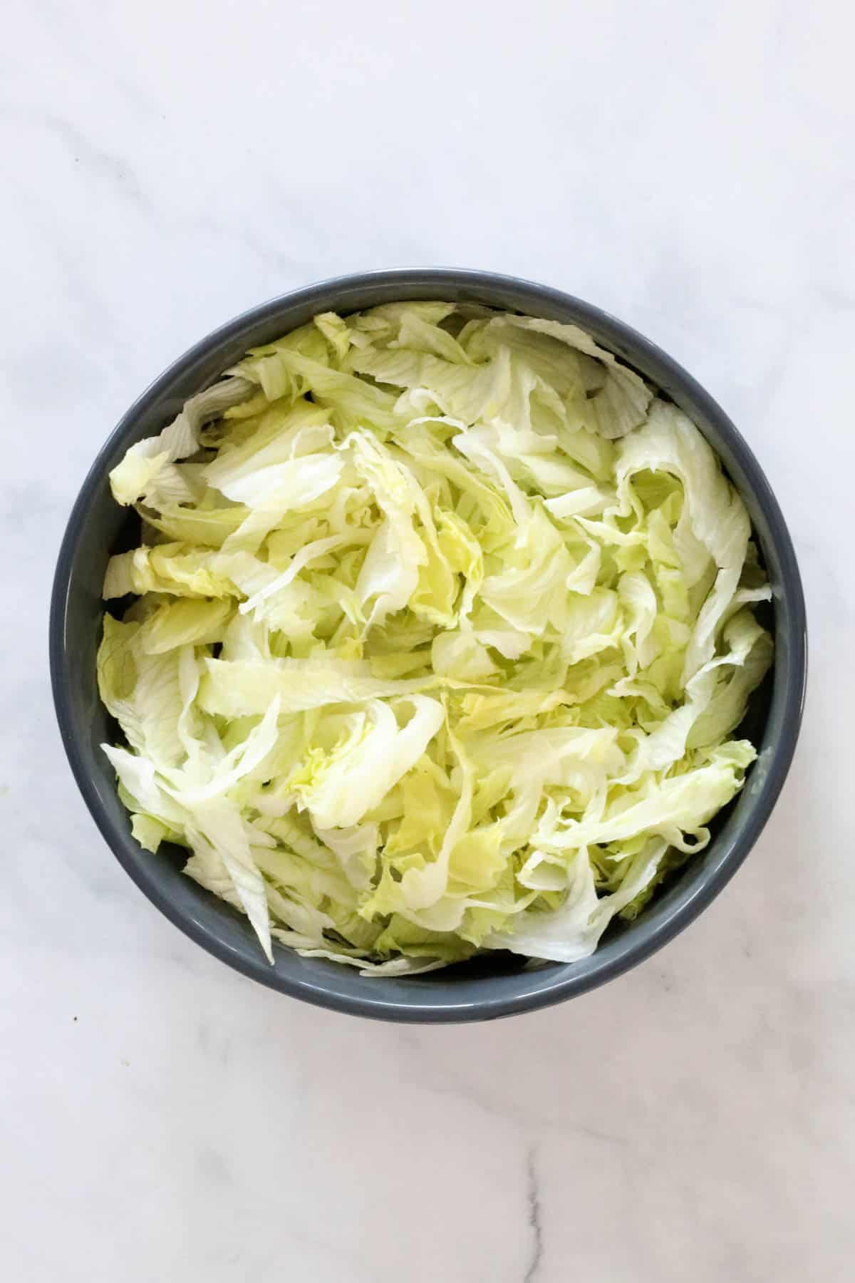 Chopped lettuce in a large salad bowl.