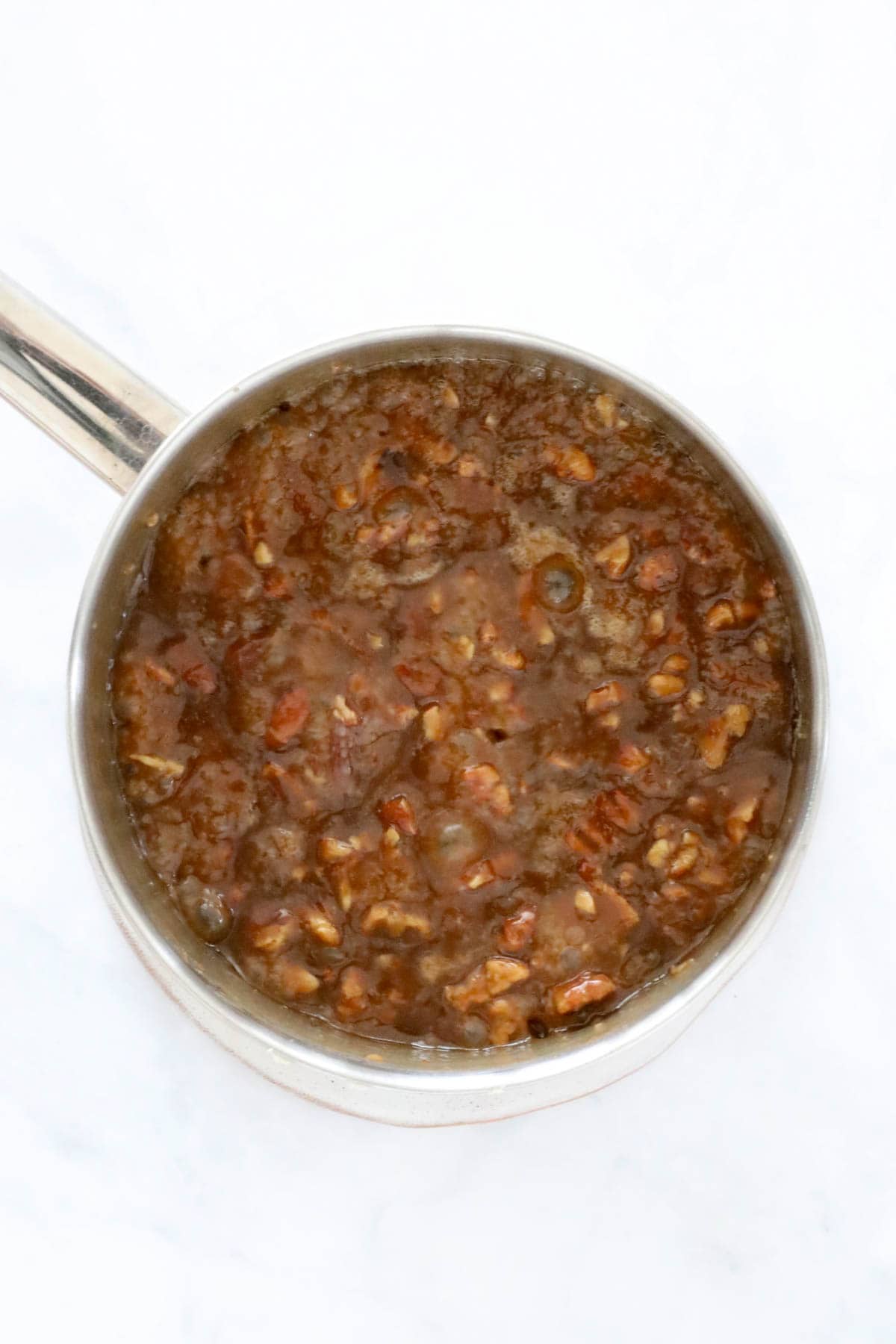 Pecans added to the caramel mixture in the pan.