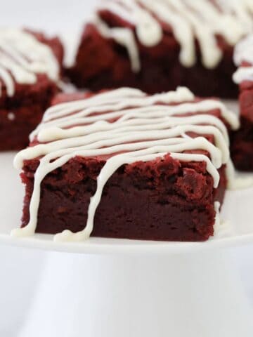 A rich and fudgy square of red velvet brownie drizzled with white chocolate.