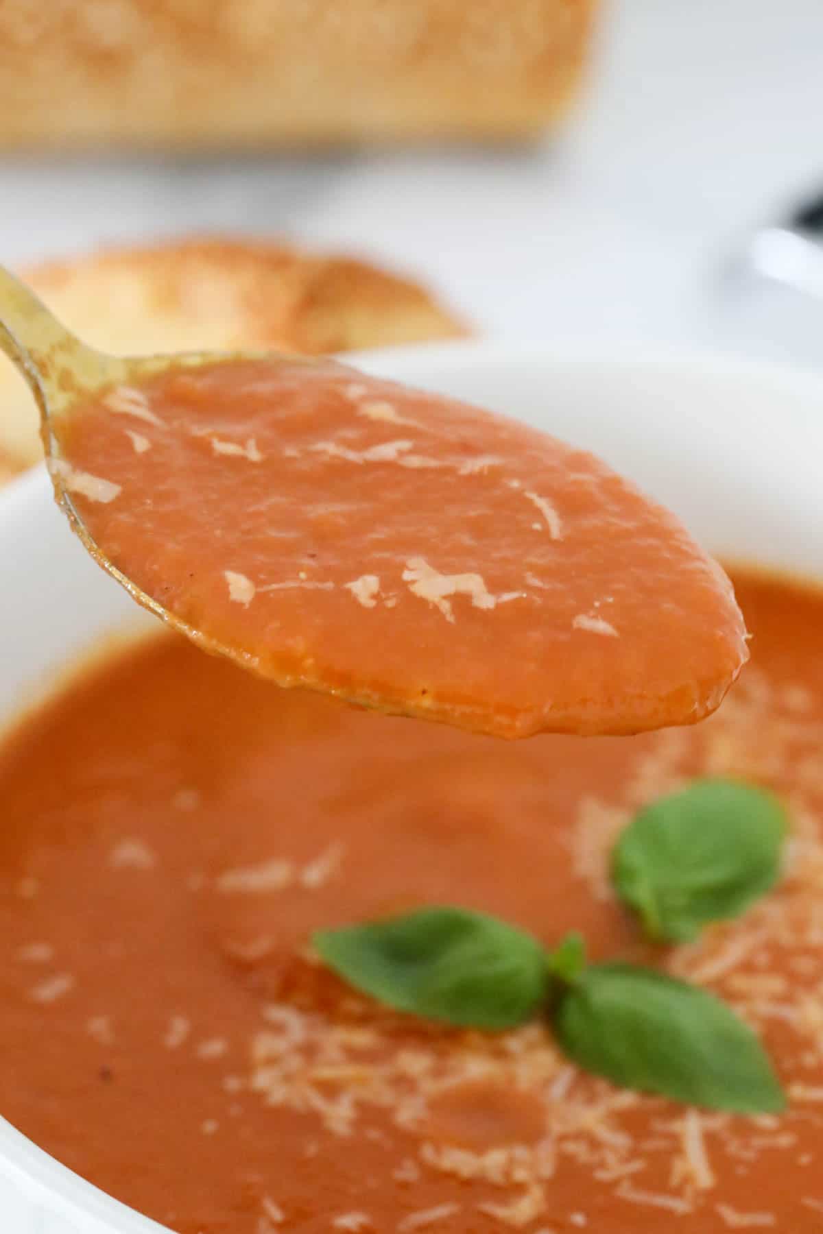 Close up of a spoonful of roasted tomato pepper soup to show the consistency of the soup.