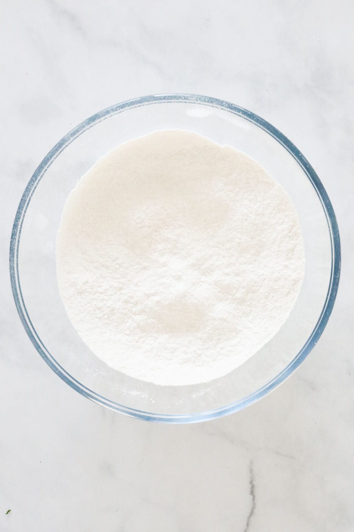 Self raising flour and baking powder sifted in to a glass bowl.