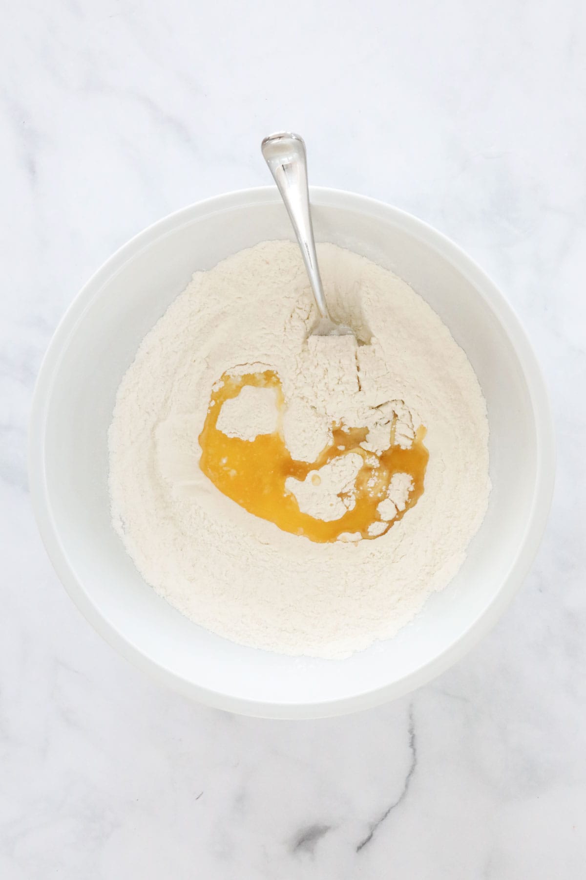 Melted butter poured into the sifted flour.