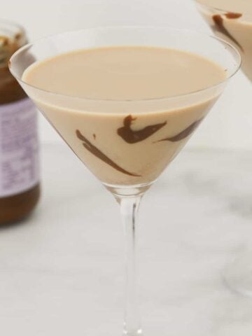 A martini glass filled with a creamy salted caramel cocktail.