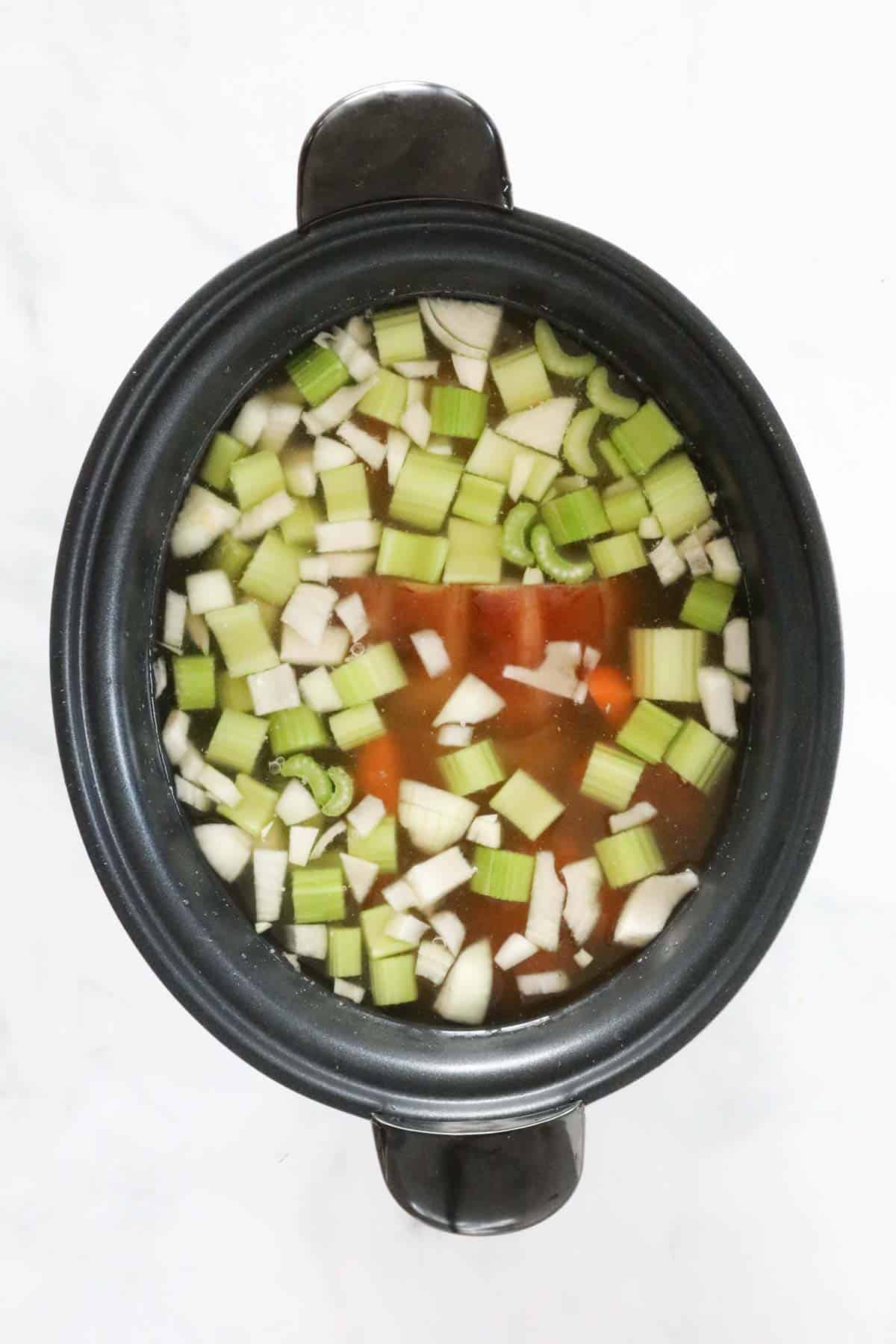 Liquid vegetable stock added to the slow cooker.