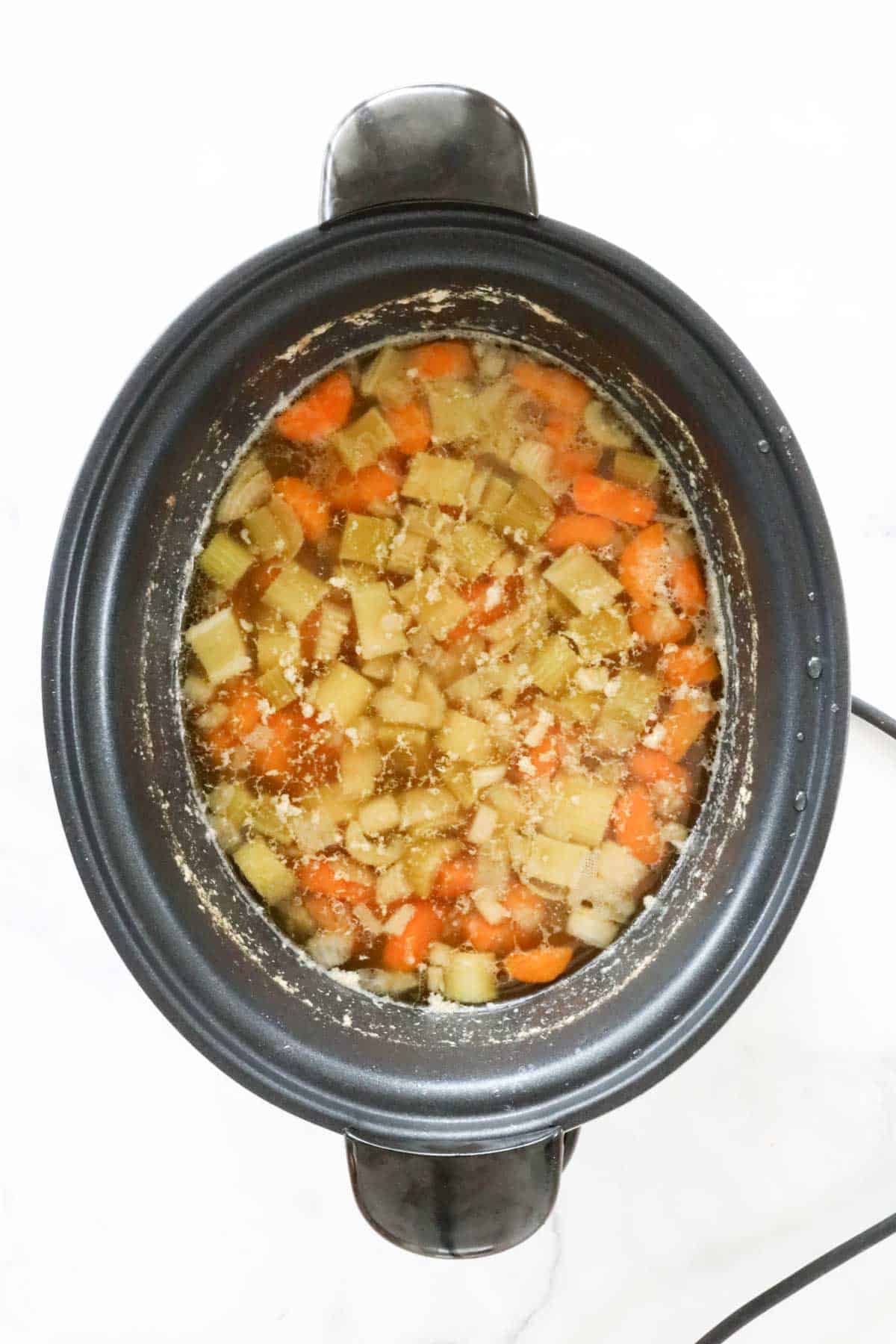Cooked split pea and vegetable soup before being blended.