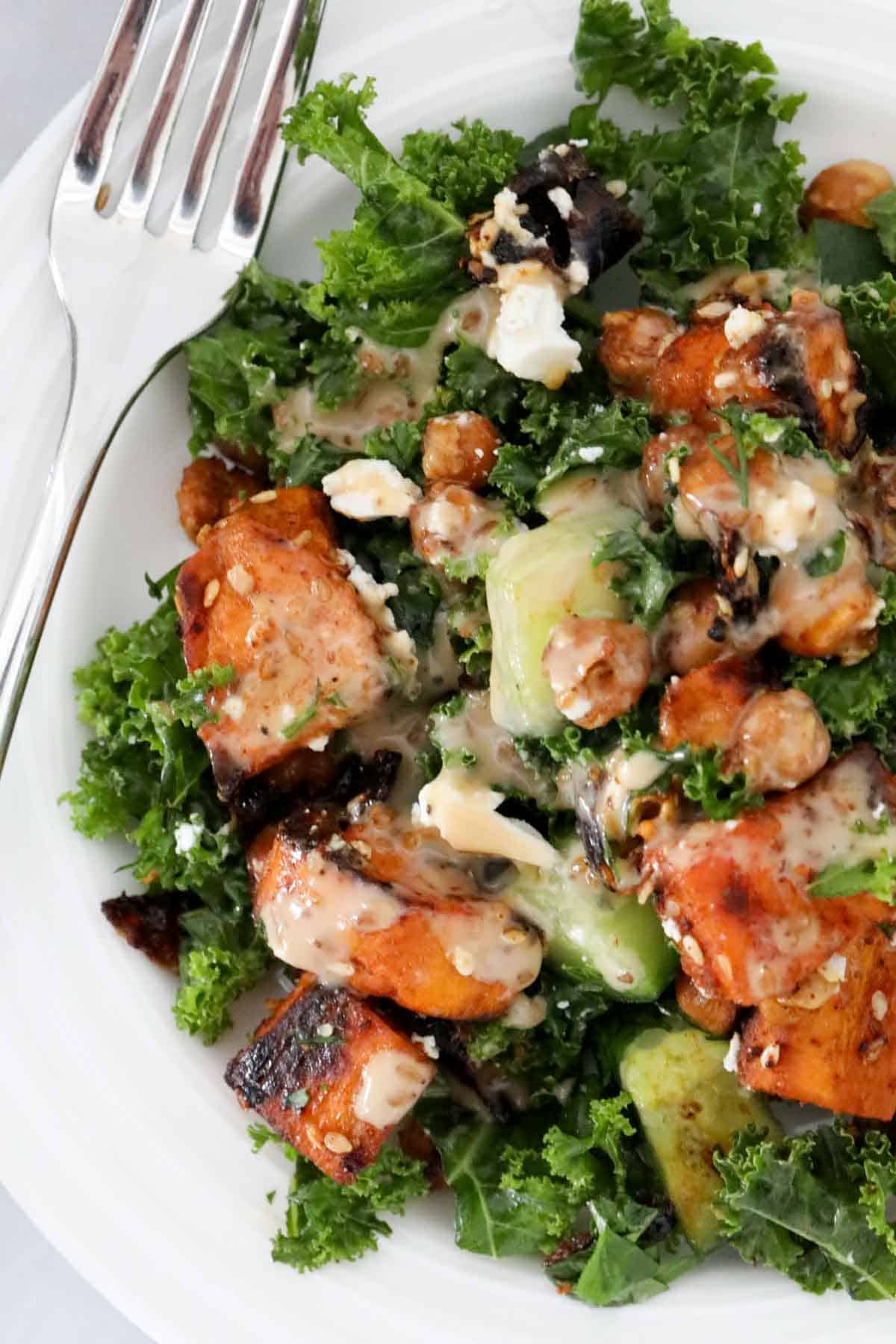 Overhead photo of sweet potato and kale salad served on a white plate.