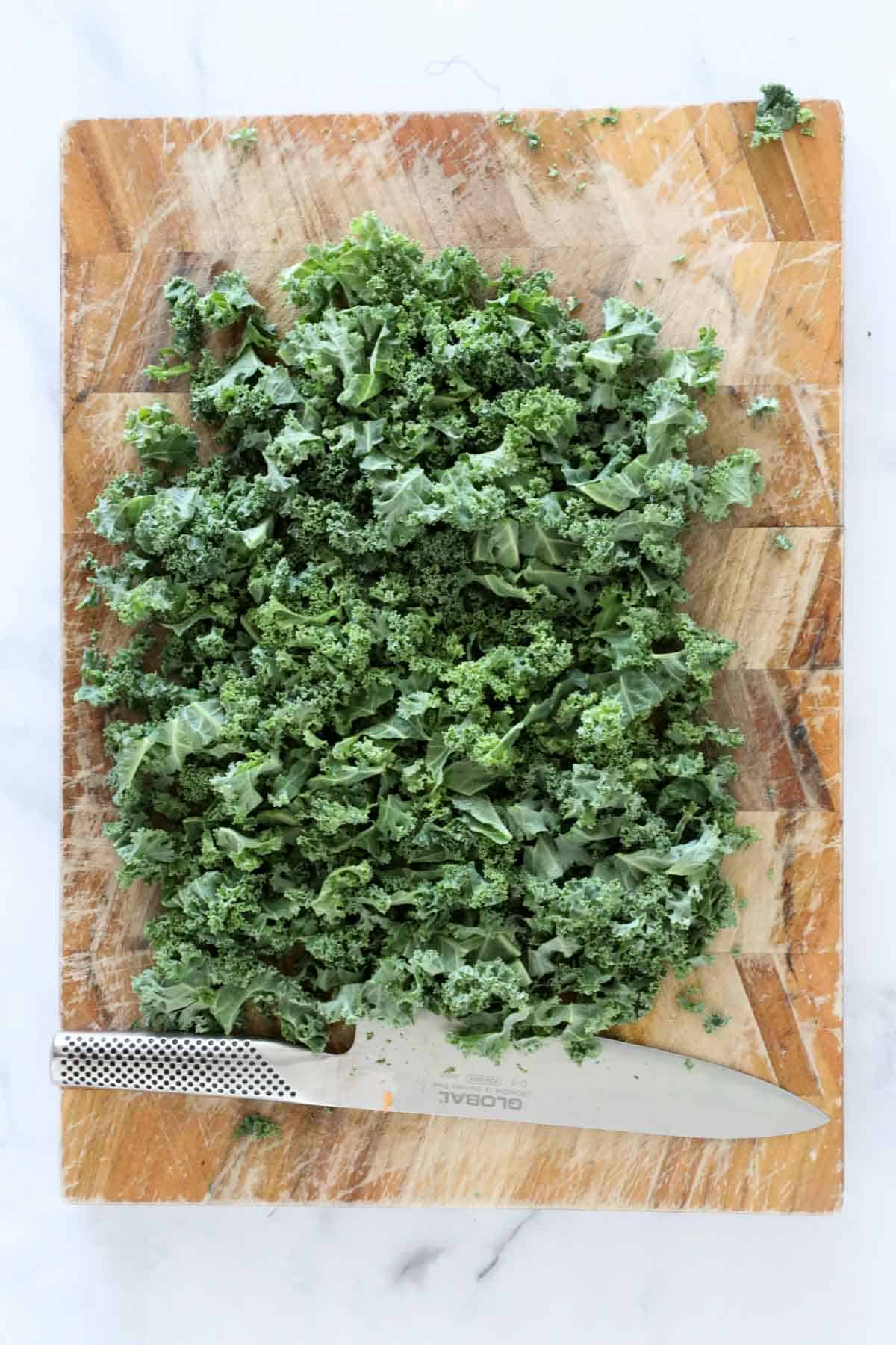 Chopped kale on a wooden chopping board.