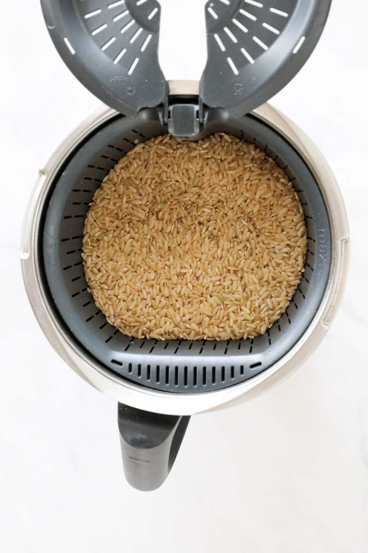 Rinsed brown rice in a simmering basket.