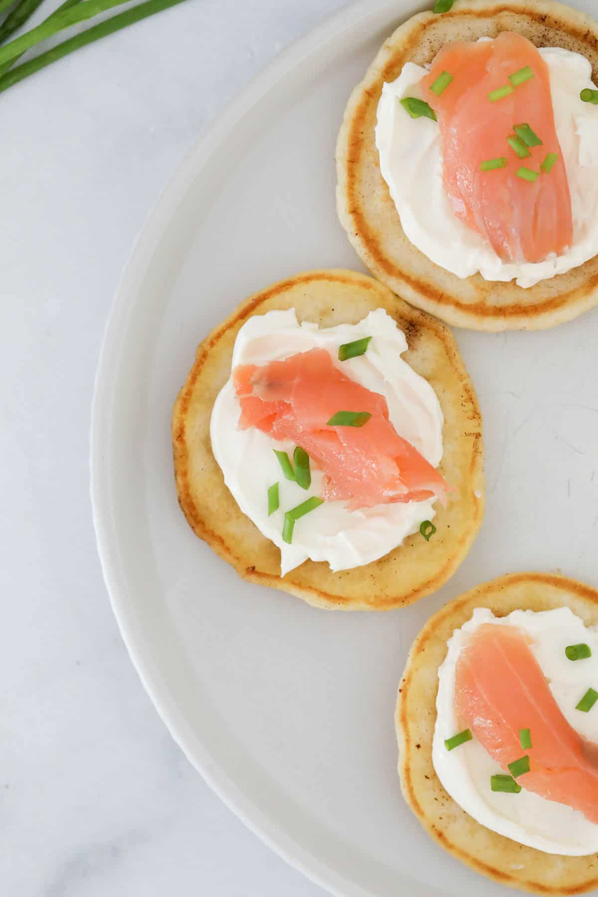 Small pieces of salmon on cream cheese and blinis, served as hors d'oeuvres.