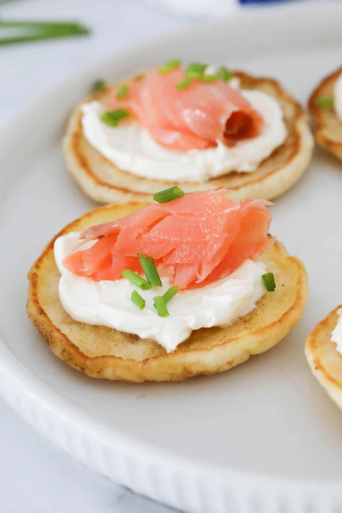 Flaked salmon, cream cheese and chives on a blini.