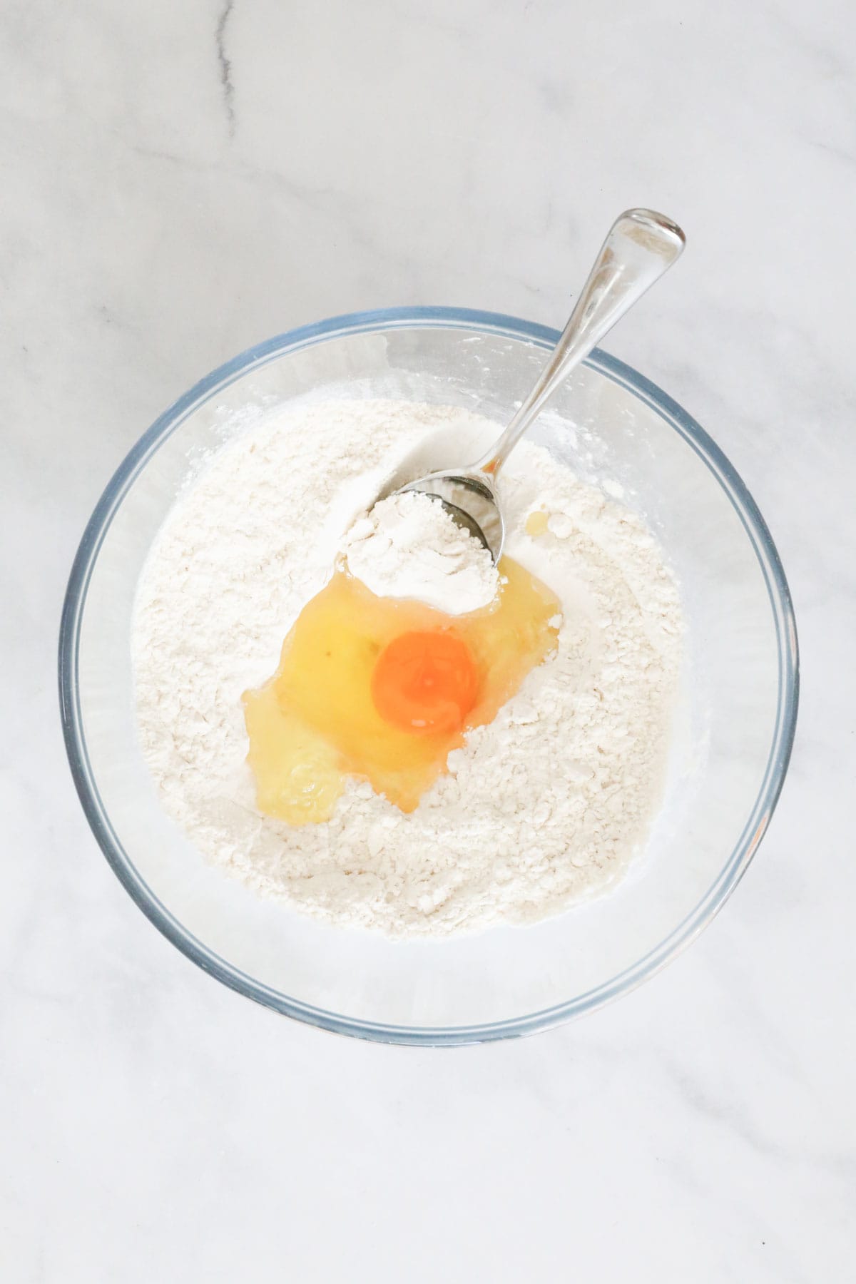 Egg and olive oil added to the flour and salt in a bowl.