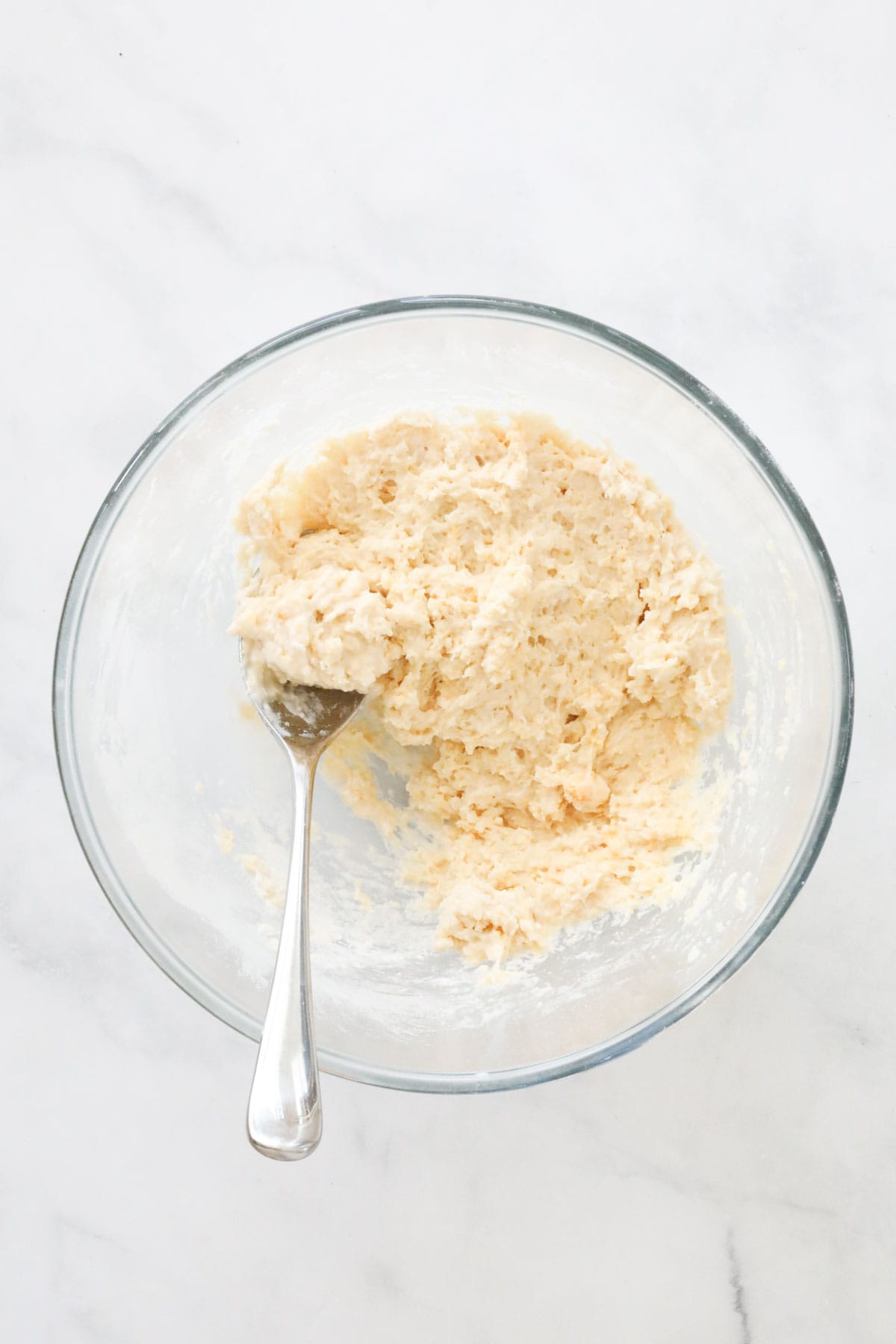 A little milk added to the flour and egg mix in a bowl.