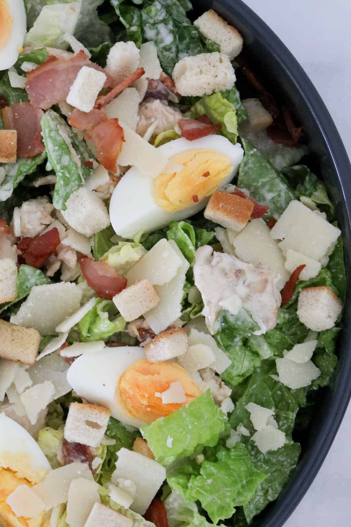 Close up of chicken Caesar salad in a serving bowl.