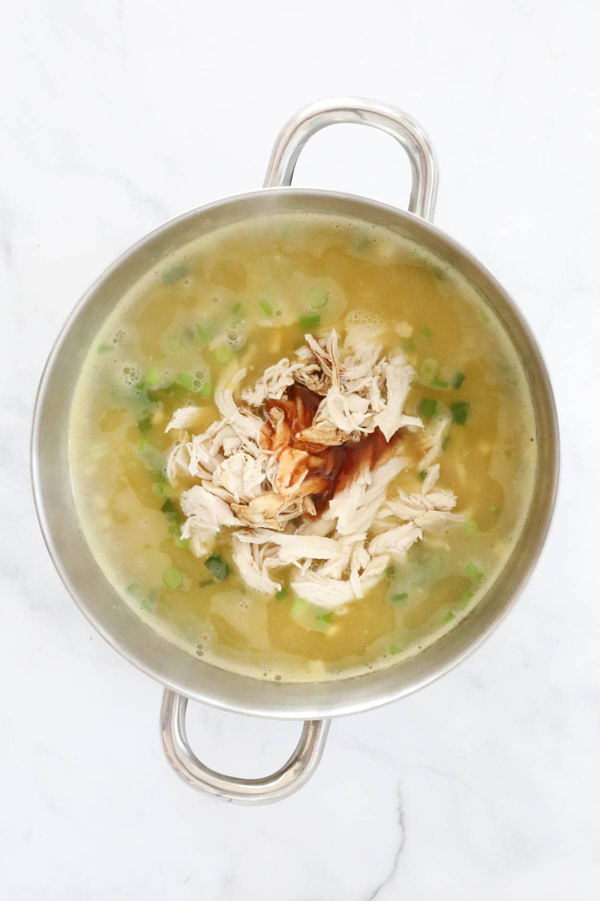 Chicken, sweet chilli sauce and soy sauce added to a pot of soup.