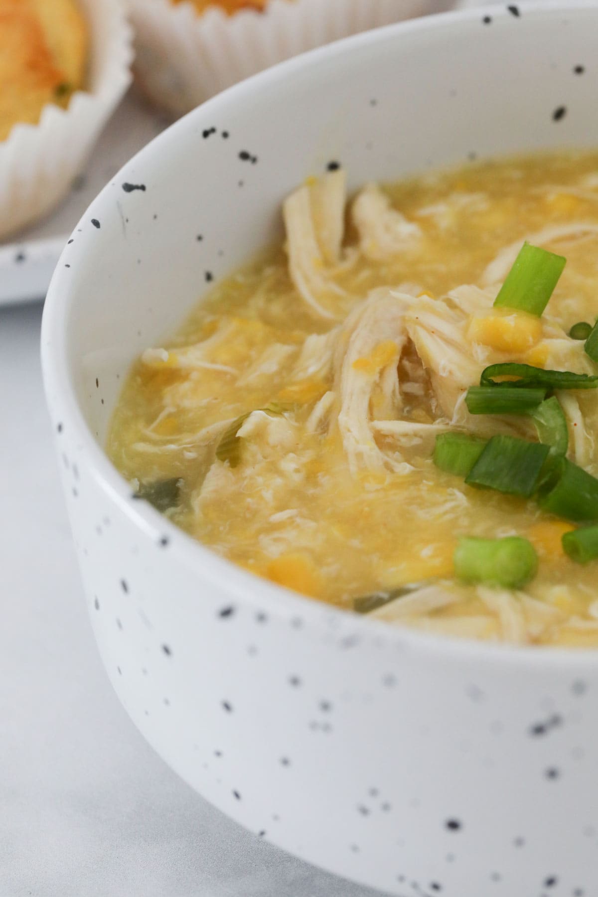 A bowl of chicken and corn soup.