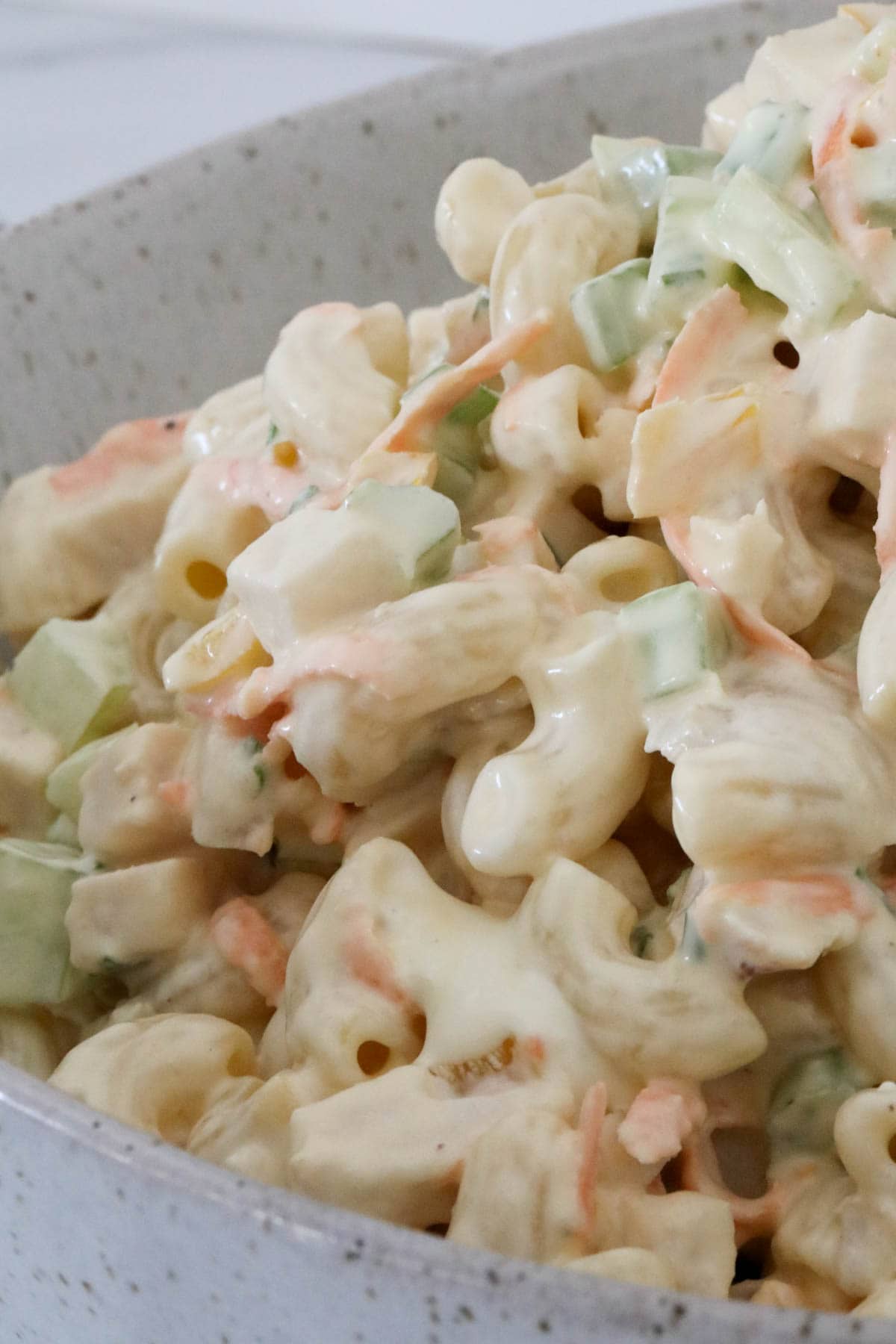 Side view of a bowl of chicken macaroni salad.