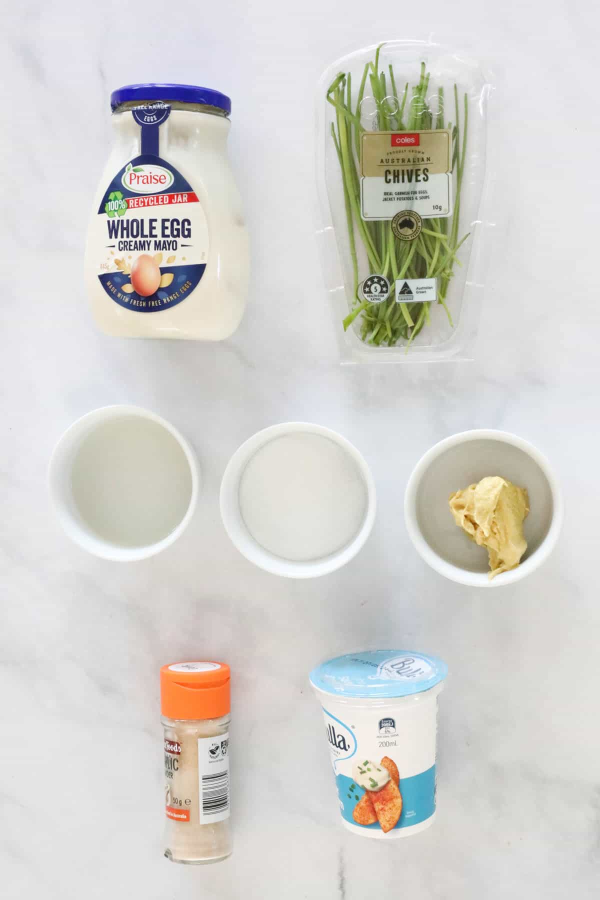 Dressing ingredients weighed out and placed in individual bowls on a bench.