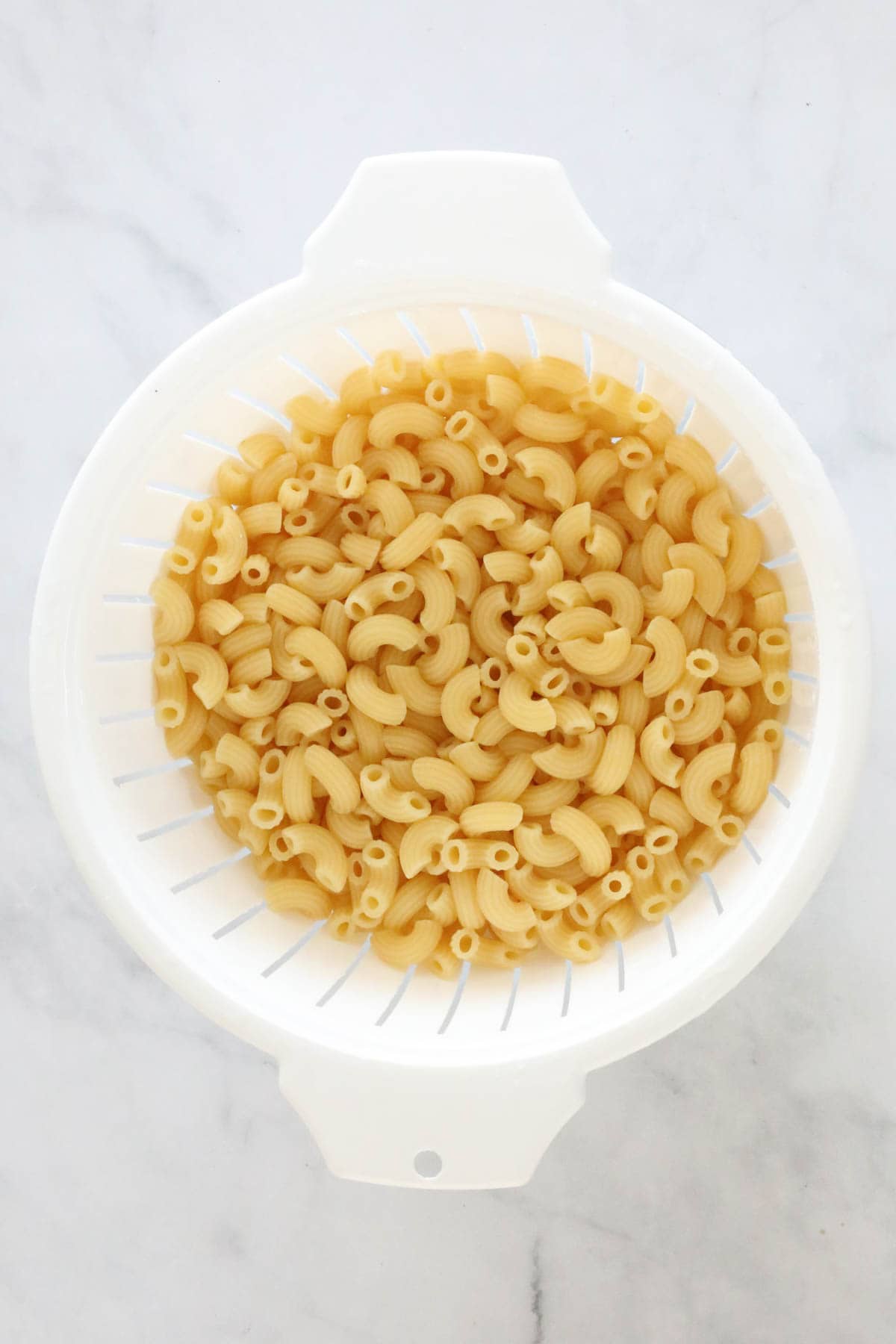 Cooked macaroni in a colander.