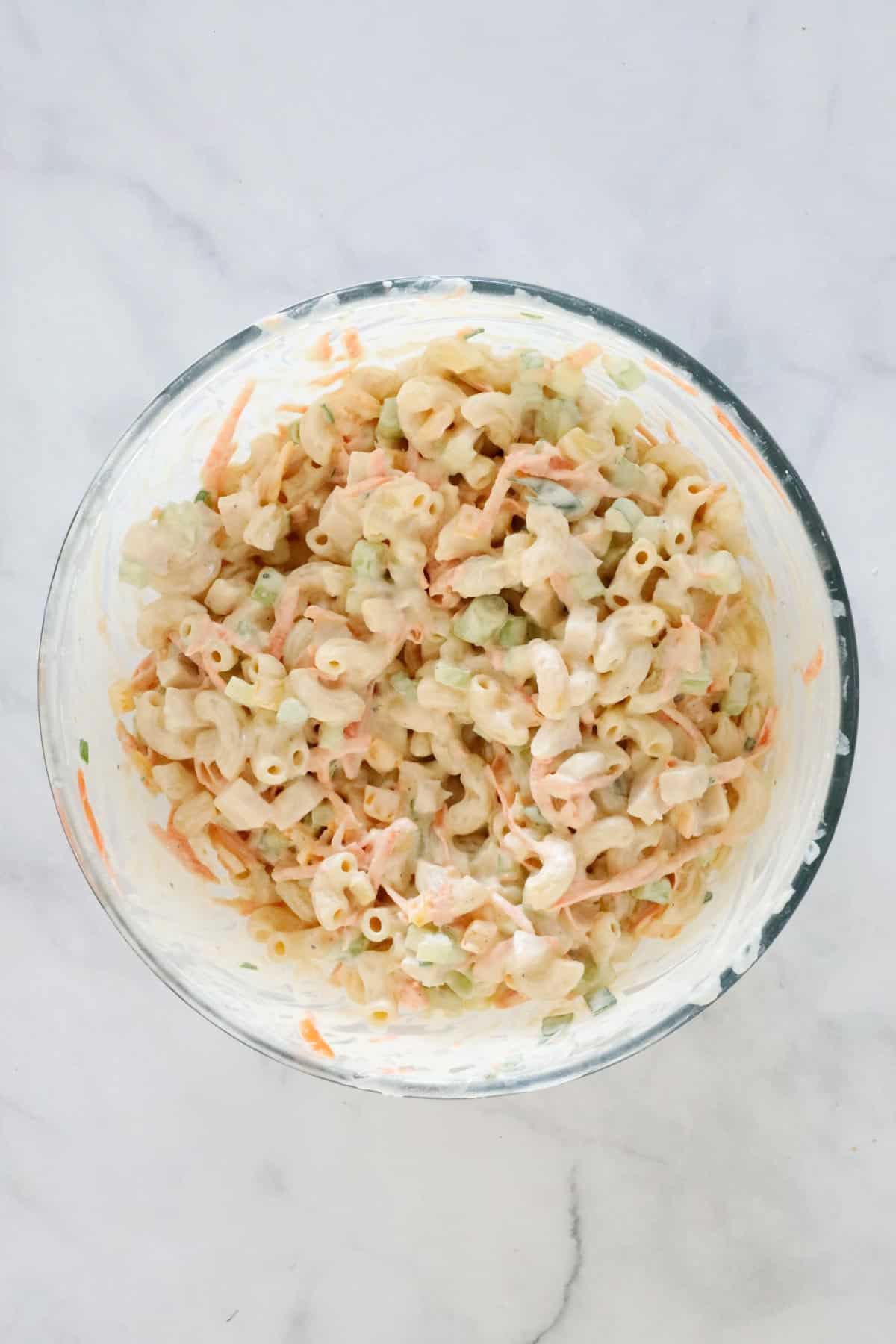 The combined salad in a large glass mixing bowl.