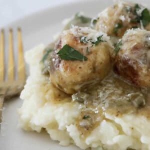 Chicken meatballs on a bed of mash potato coated in a lemon caper sauce.