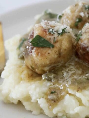 Chicken meatballs on a bed of mash potato coated in a lemon caper sauce.