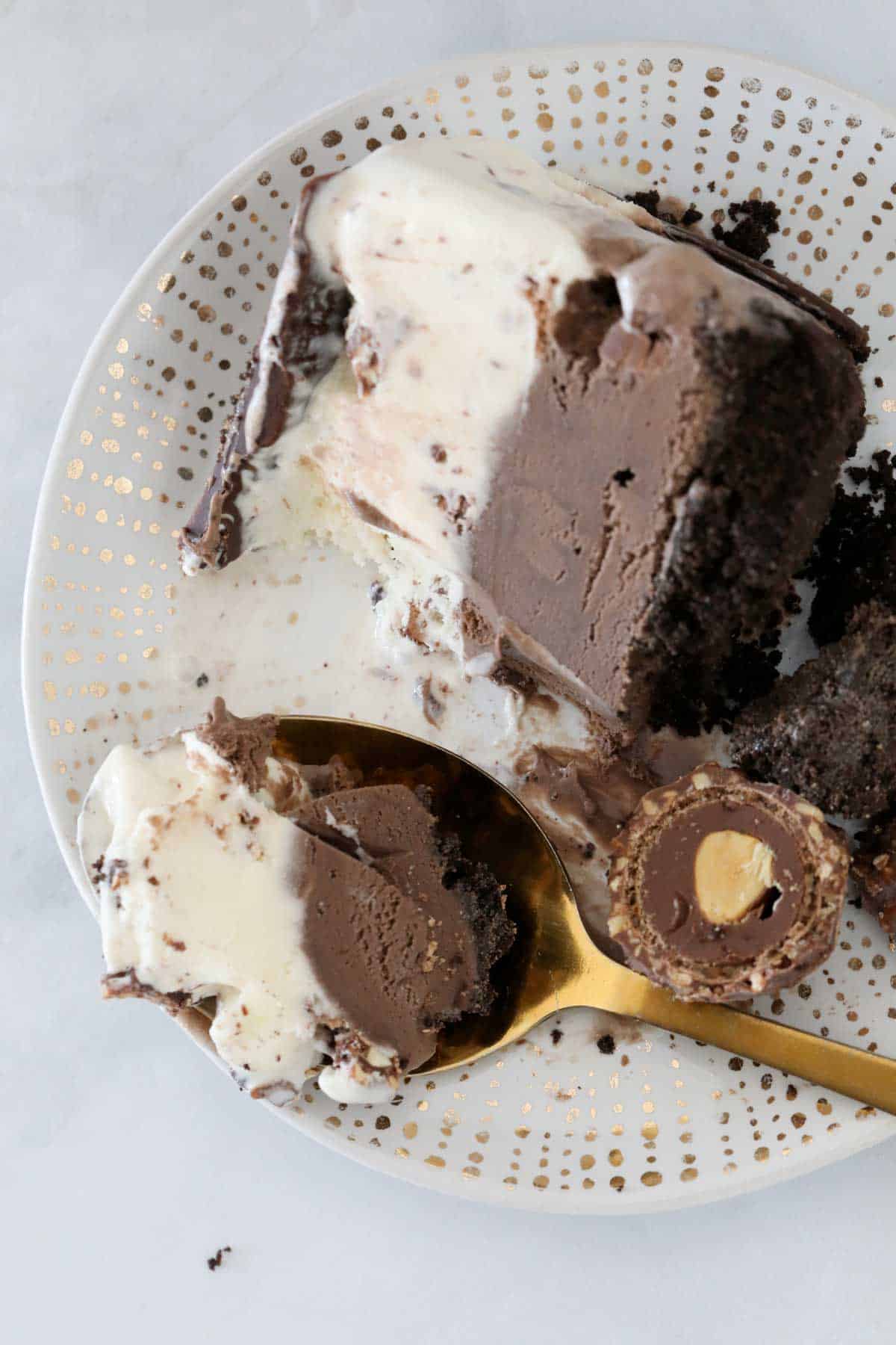 A serve of ice cream cake on a plate showing the teo layers.