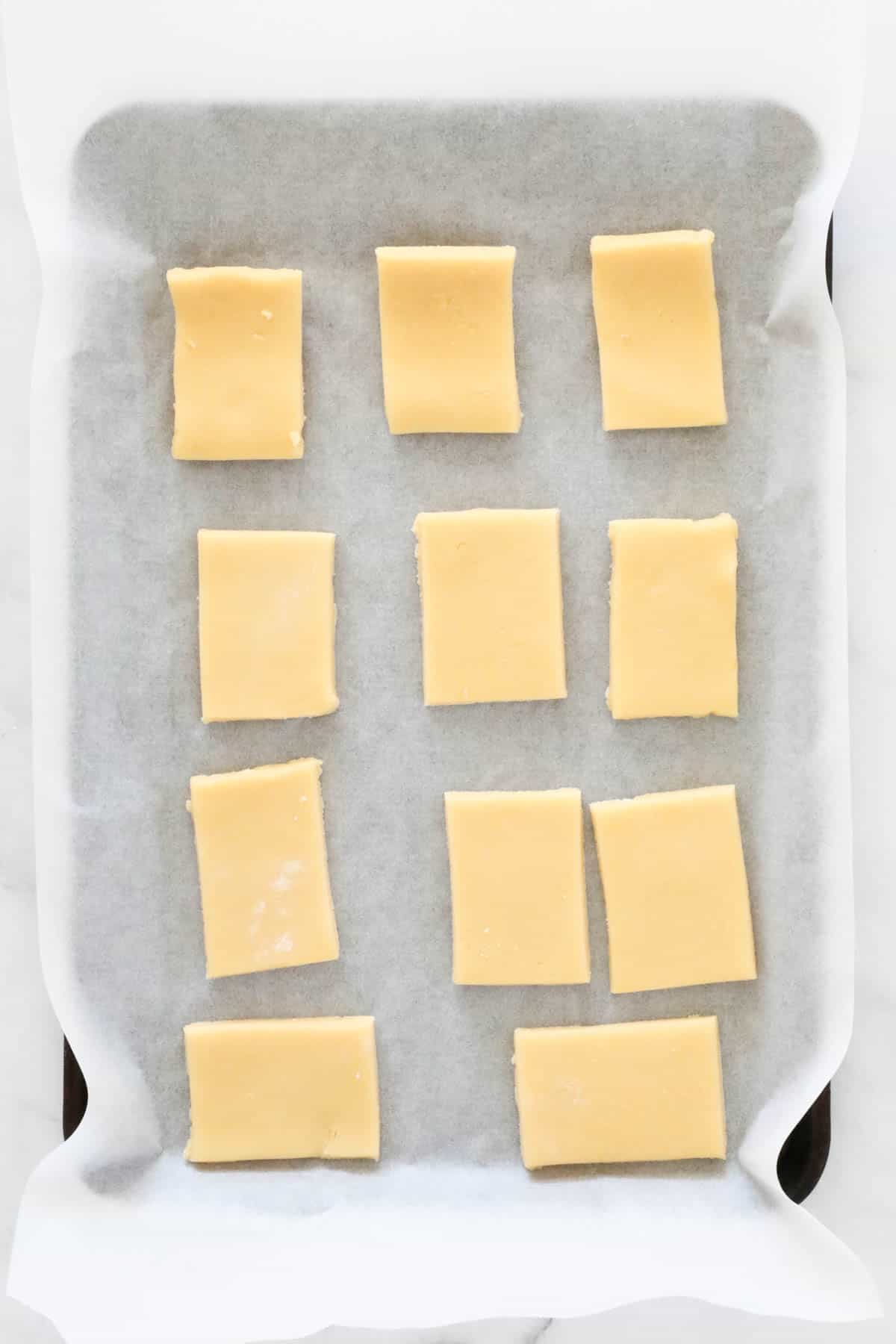 Small rectangles of dough on a lined baking sheet.