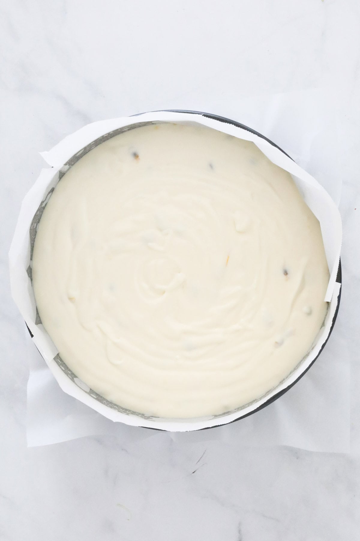 The cheesecake mixture poured into the lined tin over the crumb base.