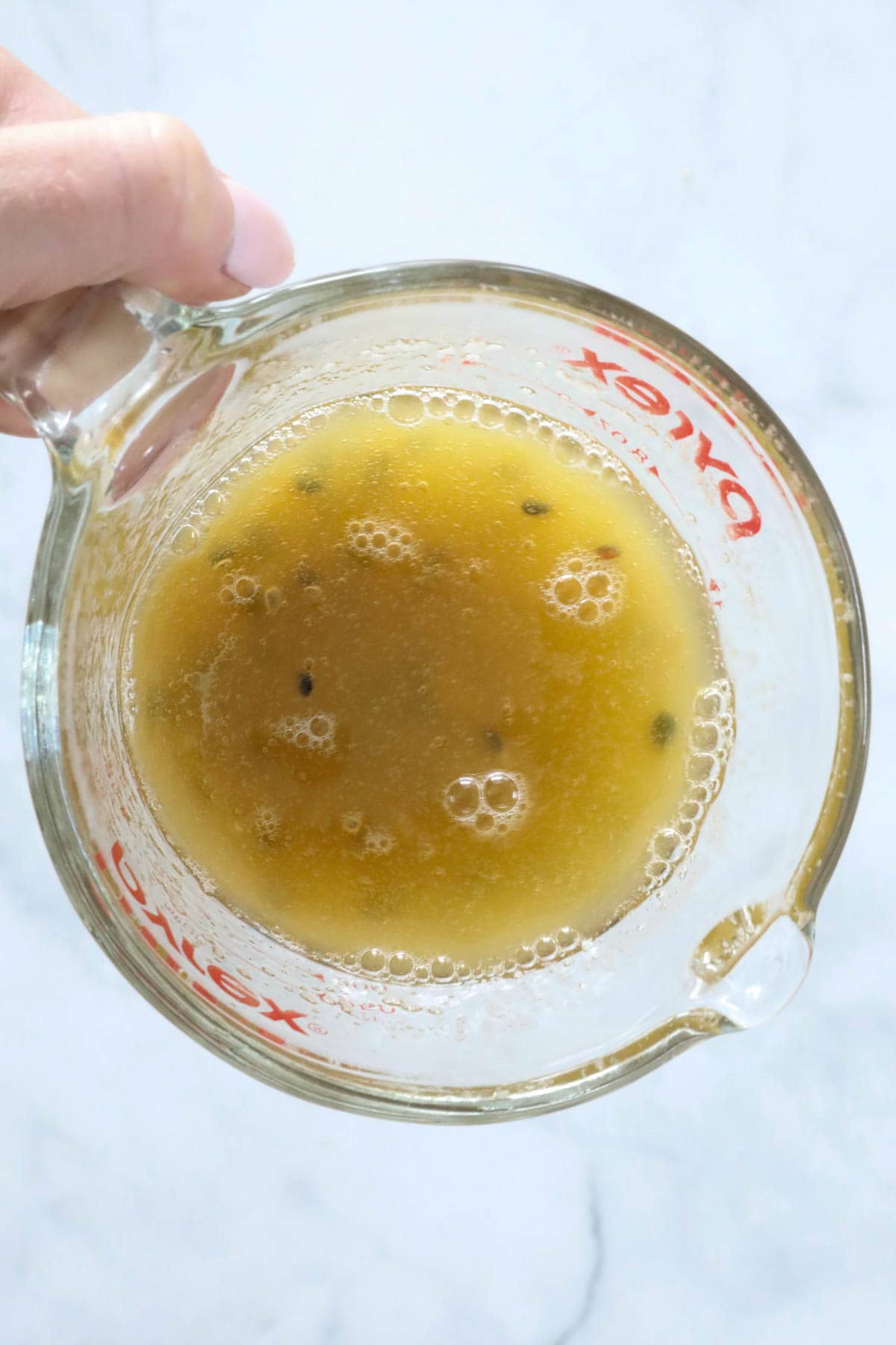 Dissolved gelatine and passionfruit pulp in a jug.