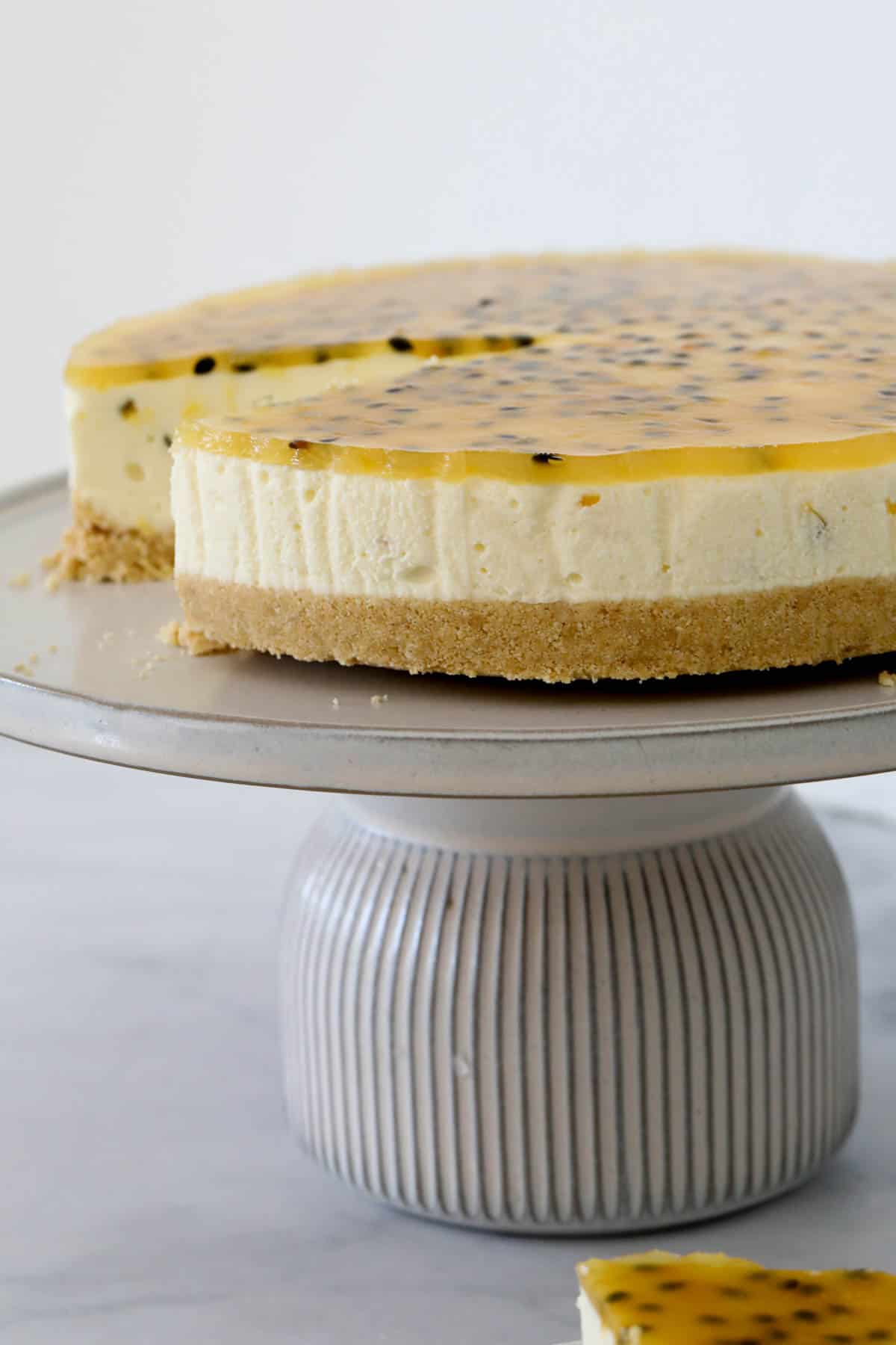 No bake passionfruit cheesecake on a cake stand.