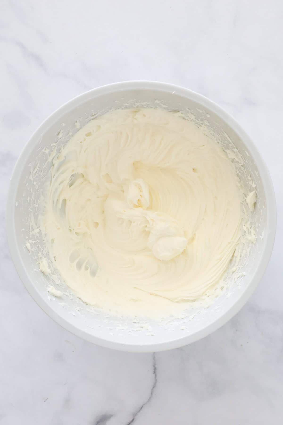 The beaten cream cheese and sugar in a bowl.