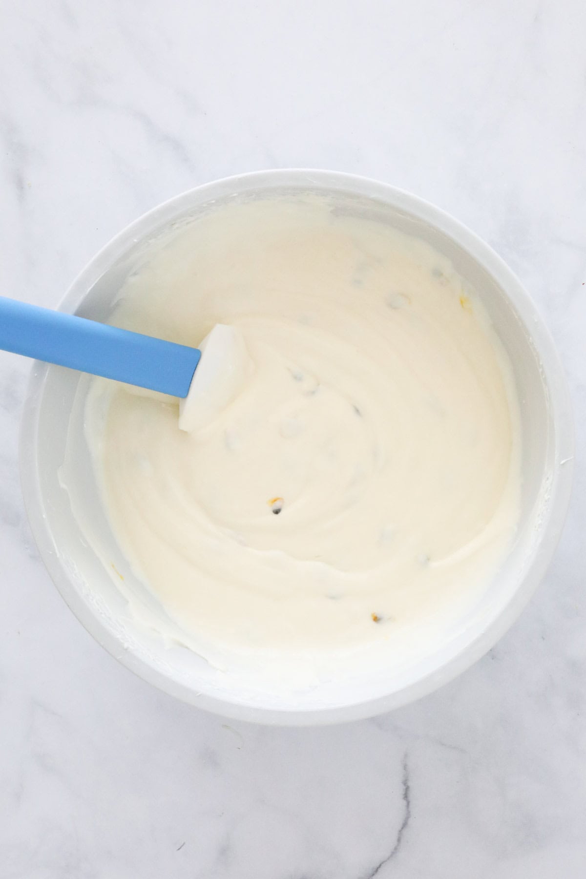 The mixed cheesecake mixture in a bowl with a spatula.