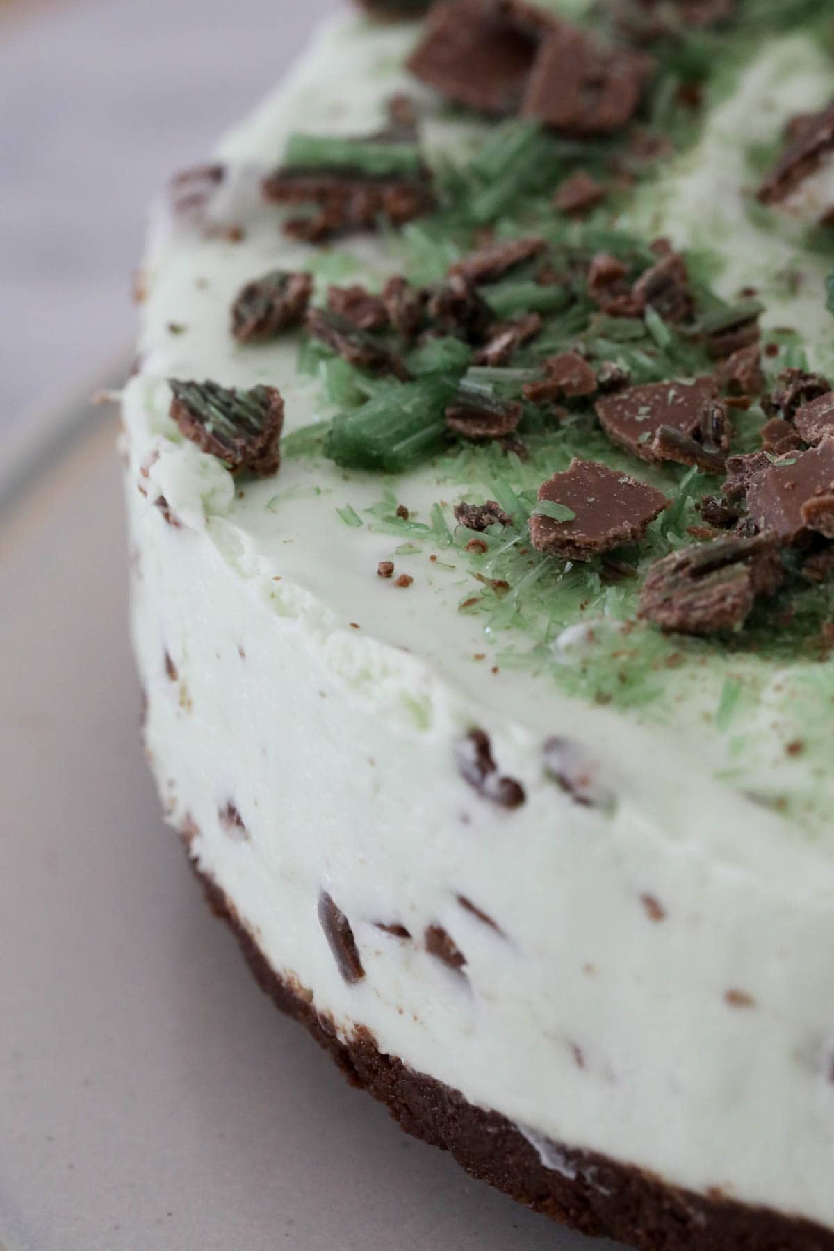 A side view of a mint cheesecake with grated Peppermint Crisp on top.