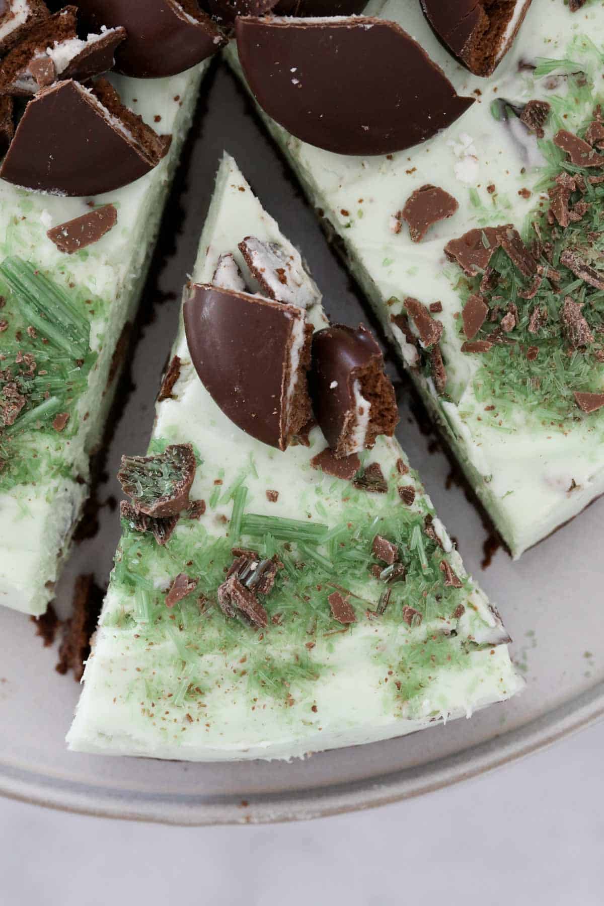 Looking down on a peppermint cheesecake with one slice slightly removed.