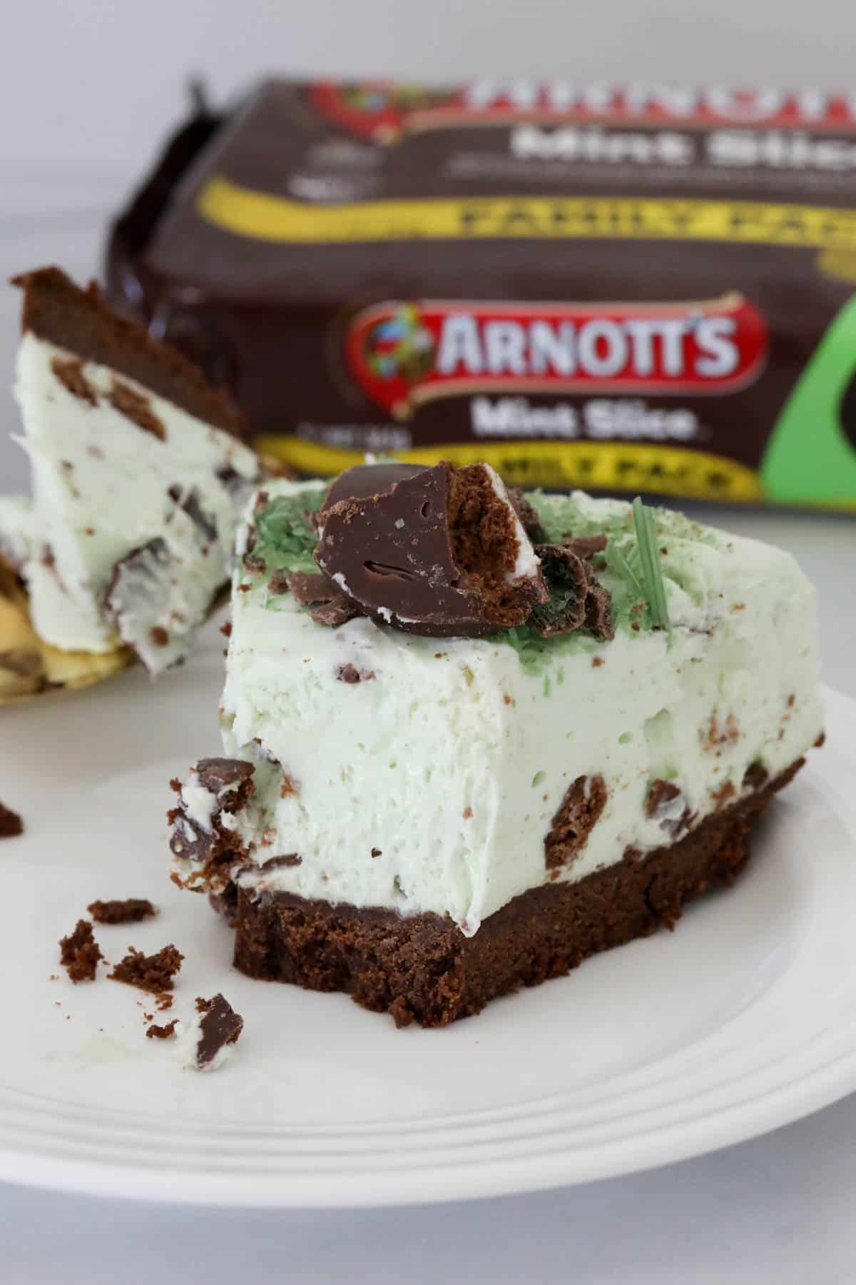 A slice of peppermint cheesecake on a plate with a forkful taken out of it to show the texture.