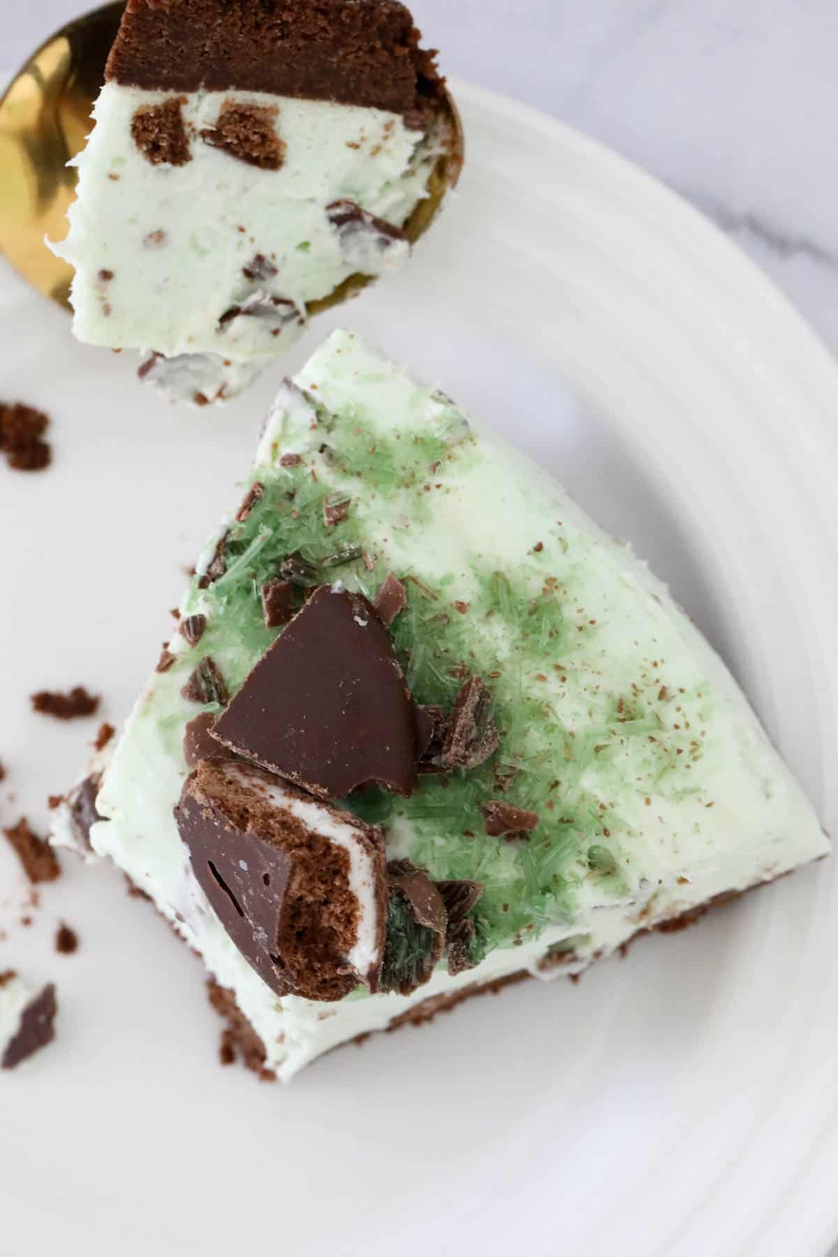 Overhead shot of a wedge of cheesecake with broken Mint Slice biscuits on top.