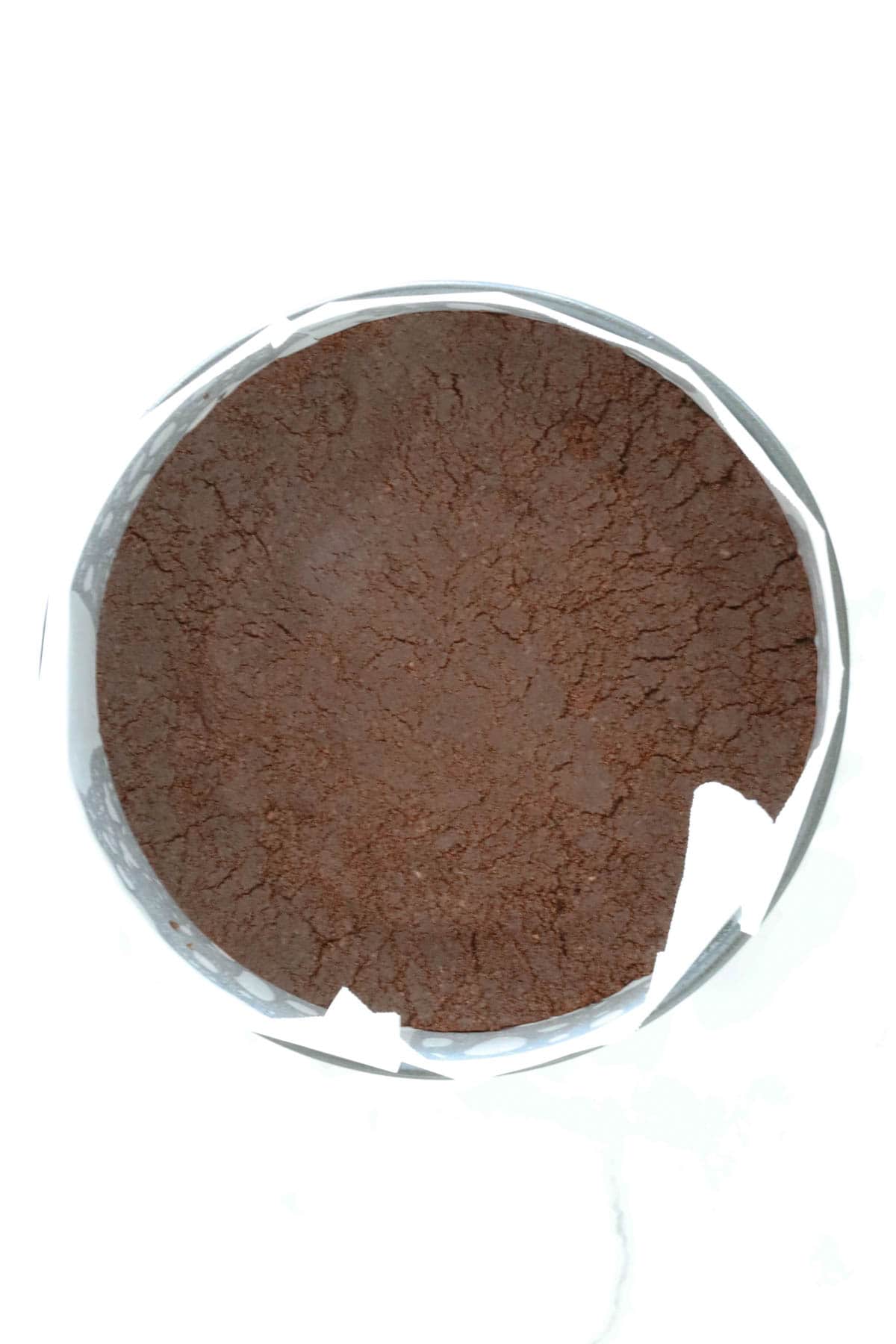 The cheesecake base mixture firmly pressed down in the base of a lined tin.